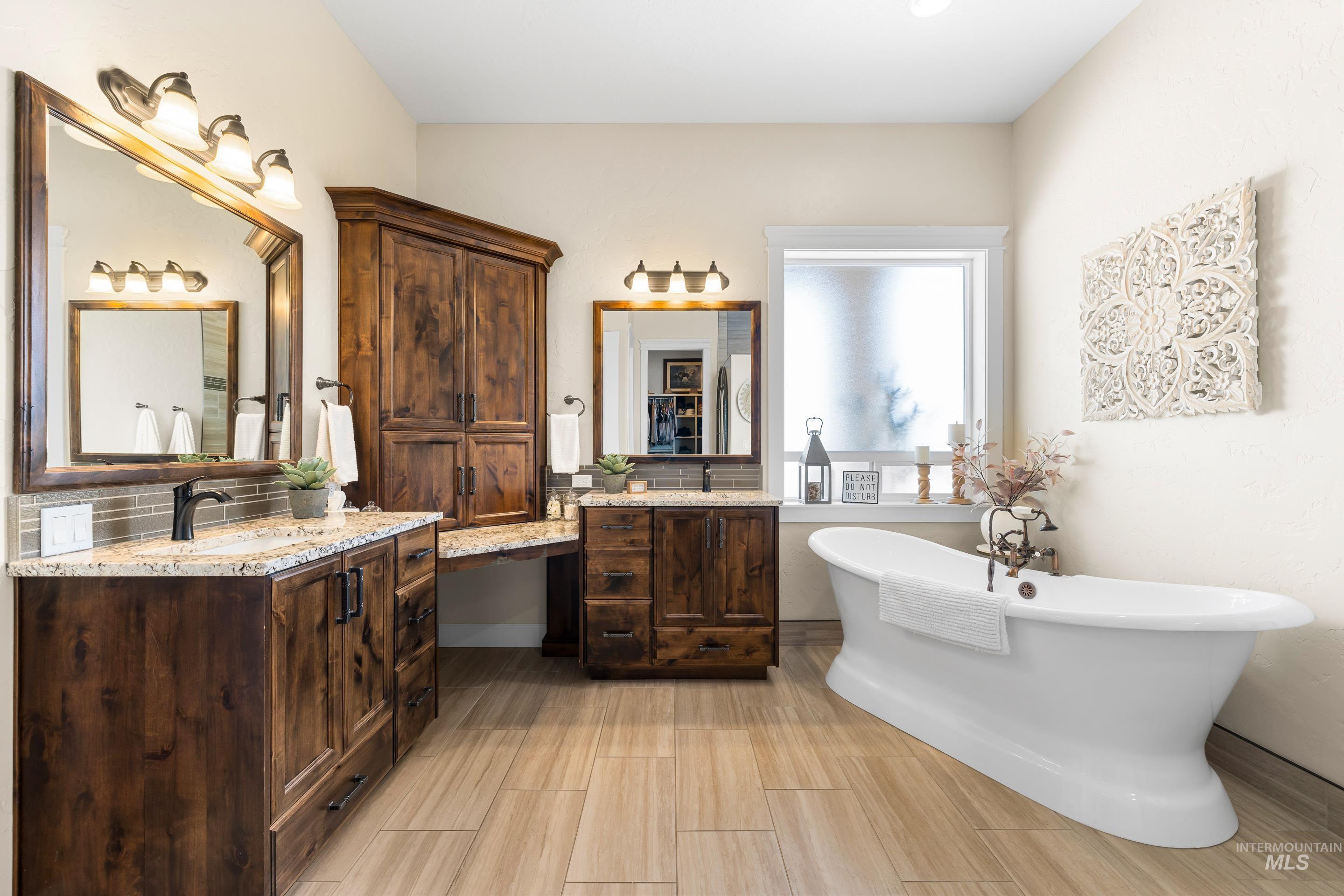 Full bath with two vanities and a freestanding tub