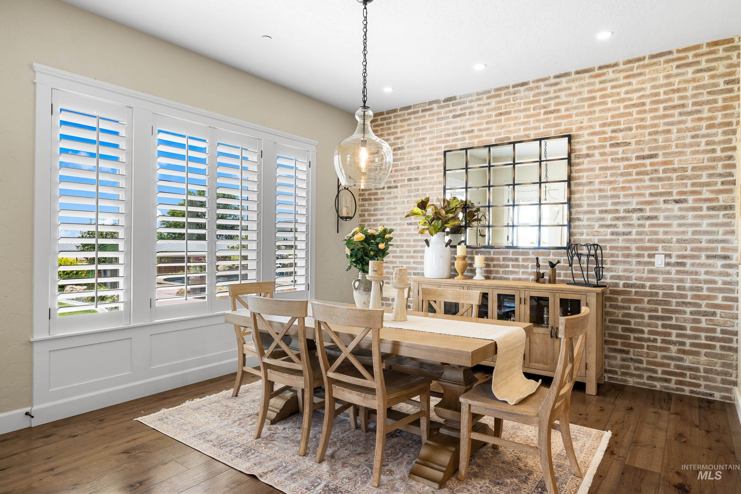 Dining area with brick wall, wood-type flooring, and recessed lighting