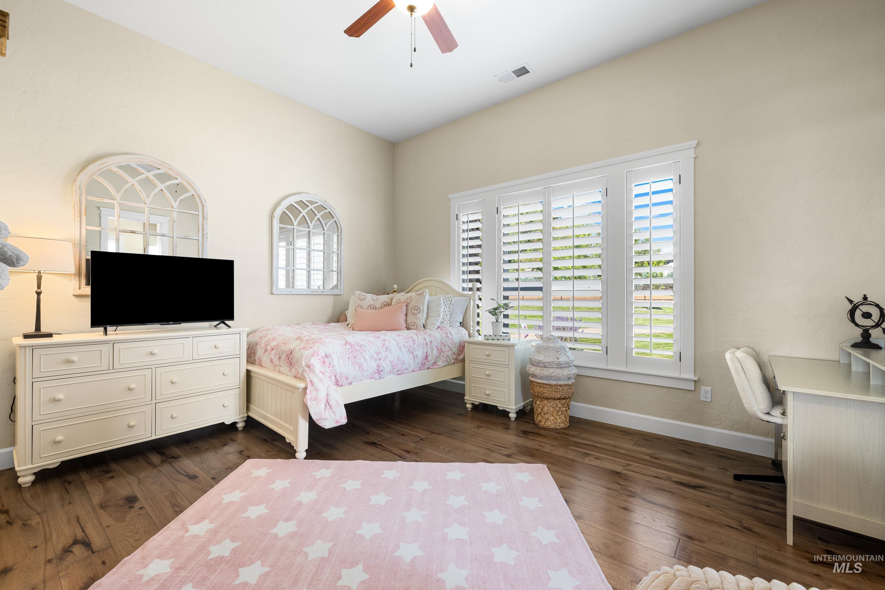 Bedroom with dark wood-style flooring and a ceiling fan