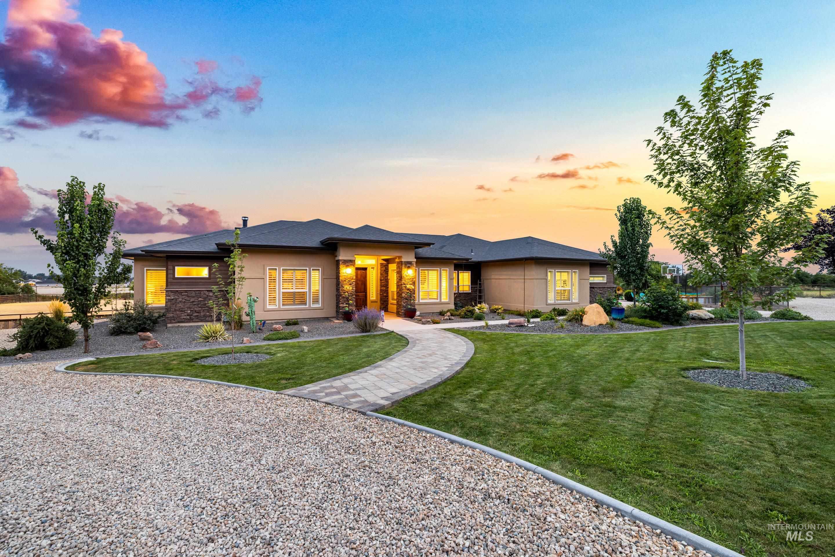 Prairie-style home featuring stone siding and a yard