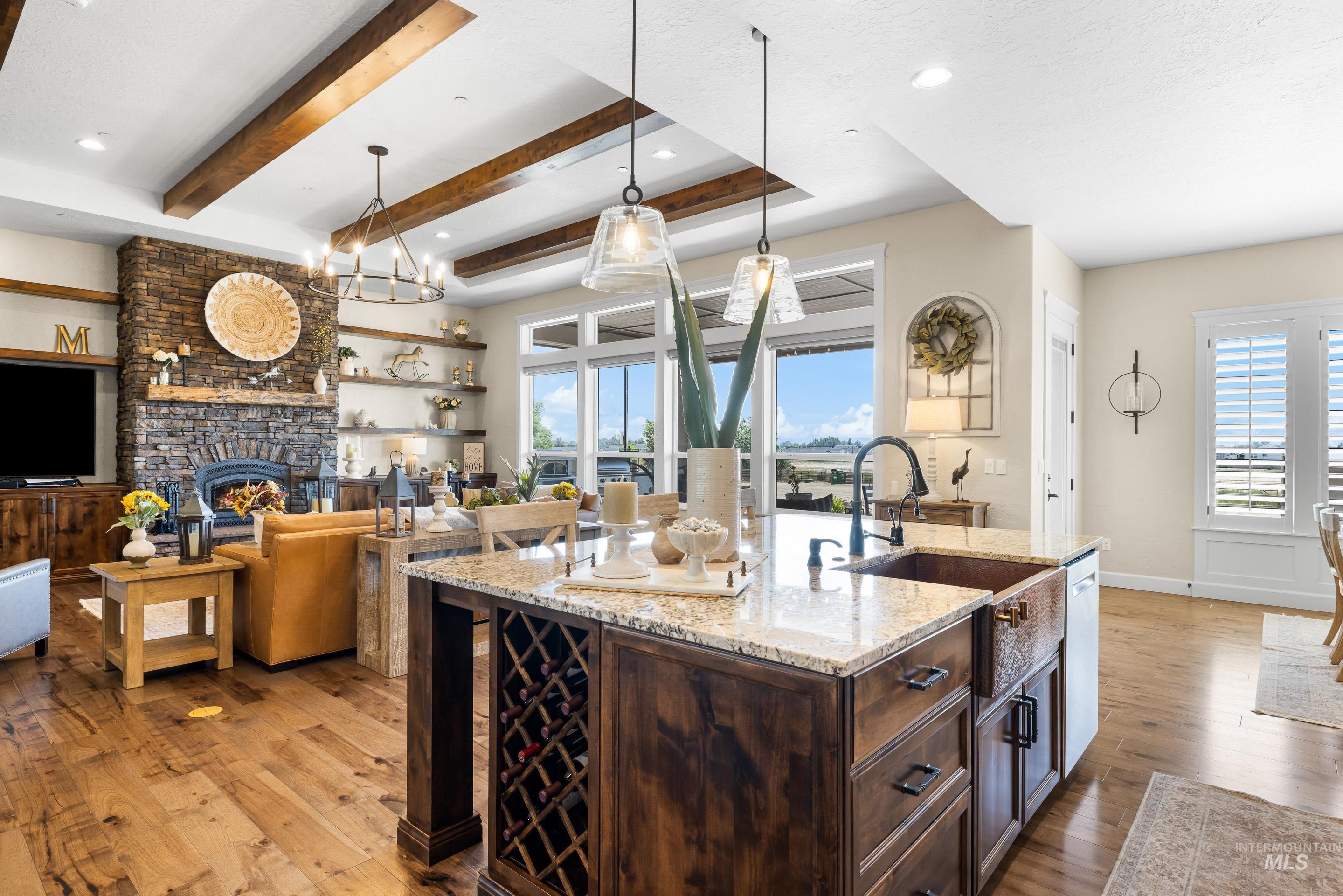Kitchen featuring light wood-style flooring, dark brown cabinets, a large fireplace, a chandelier, and recessed lighting