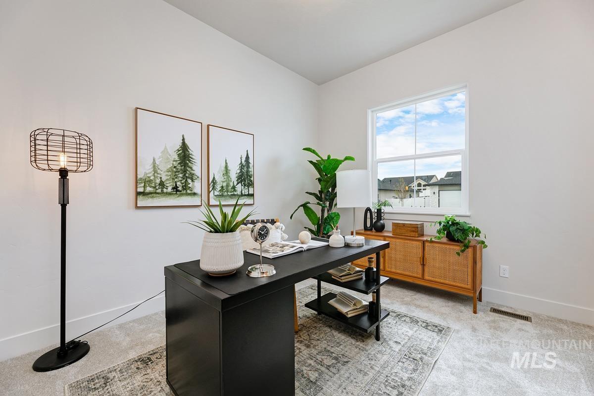 Home office with baseboards and light carpet