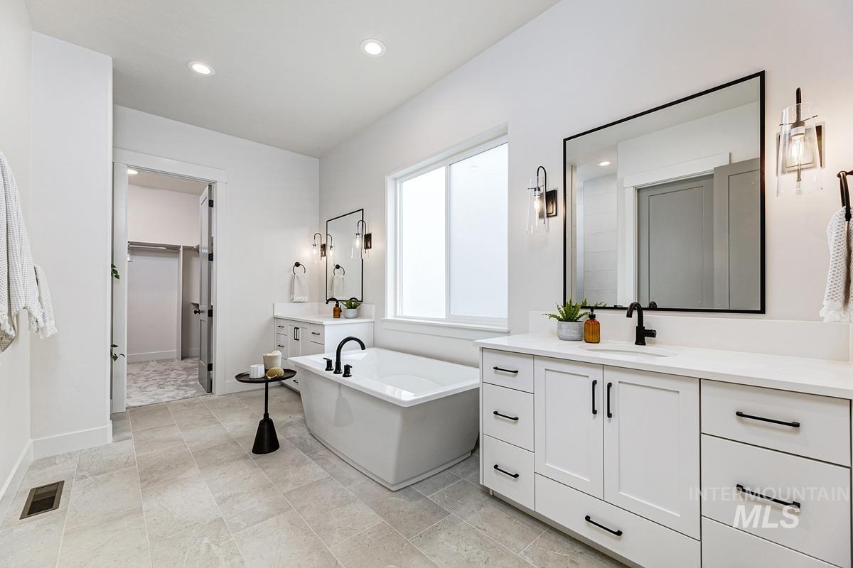 Bathroom featuring vanity, a freestanding bath, recessed lighting, and a spacious closet