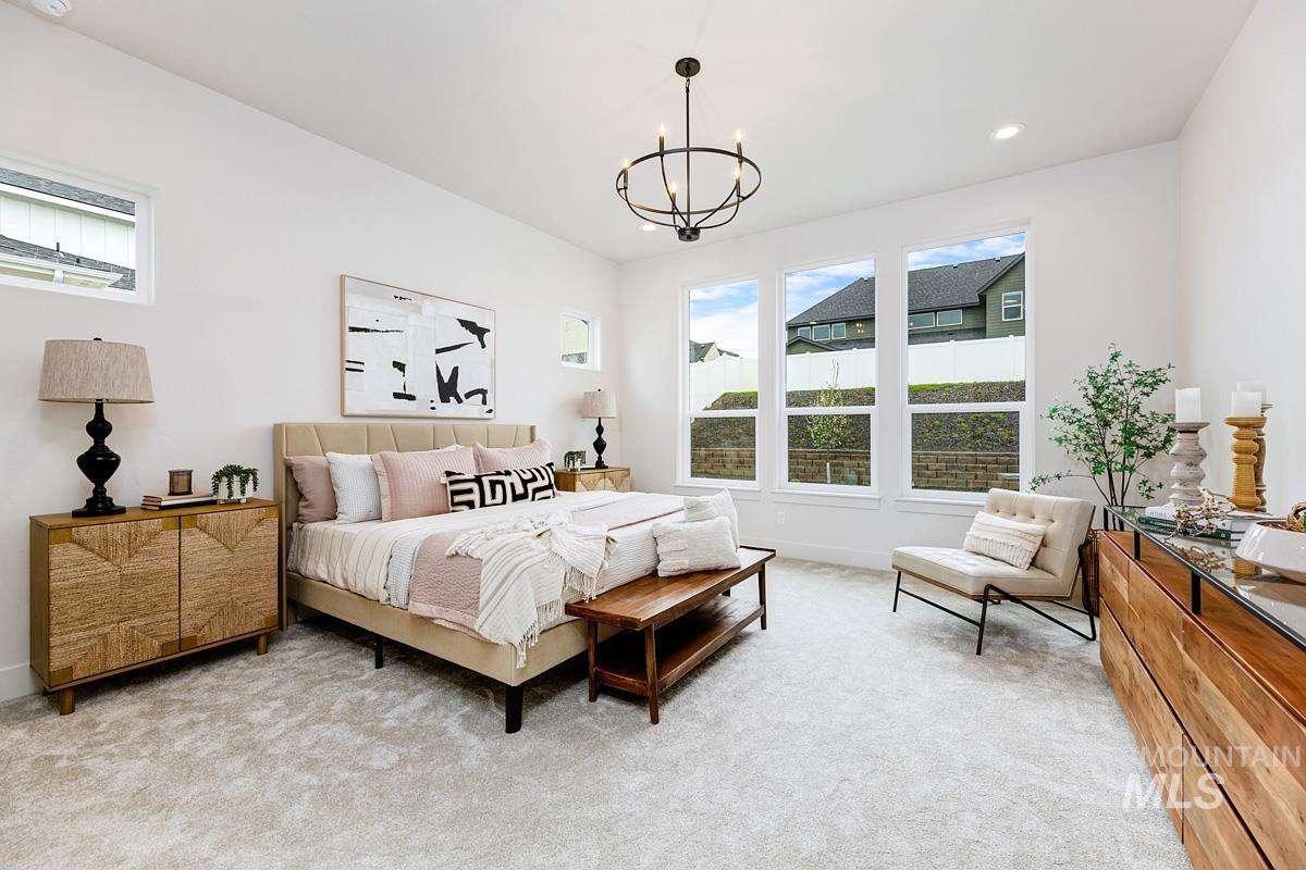 Bedroom with light colored carpet, recessed lighting, and a chandelier