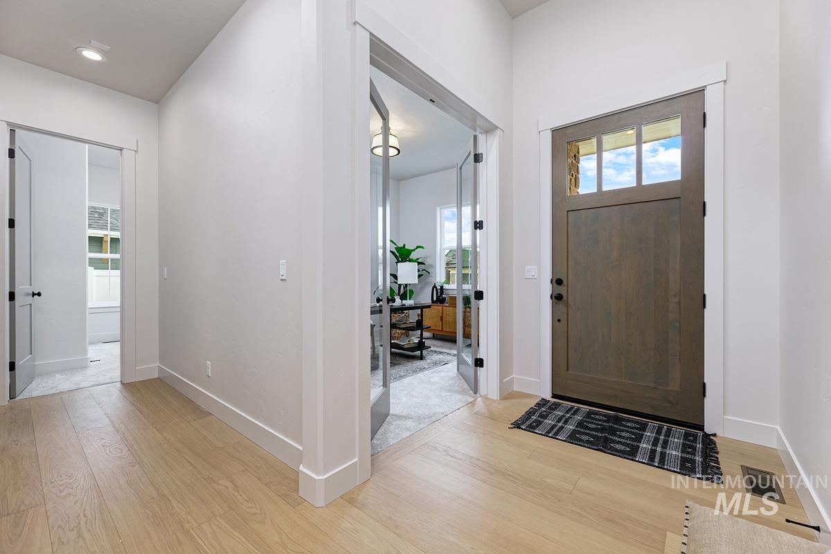 Foyer featuring baseboards and light wood finished floors