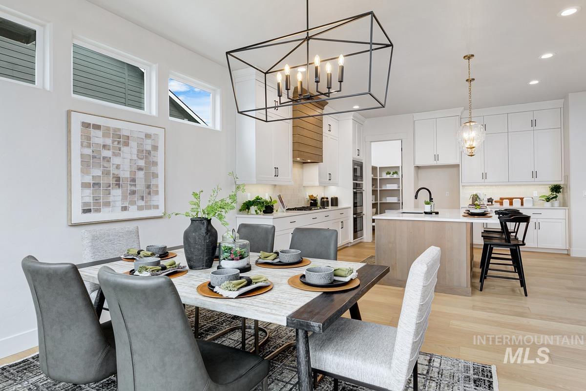 Dining space featuring a chandelier, light wood finished floors, and recessed lighting
