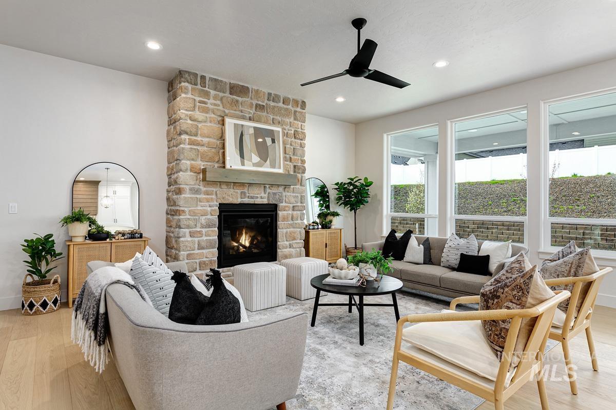 Living room with light wood-type flooring, a fireplace, recessed lighting, and a ceiling fan