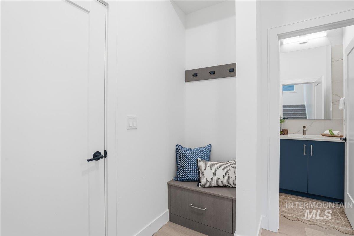 Mudroom with light wood finished floors and baseboards