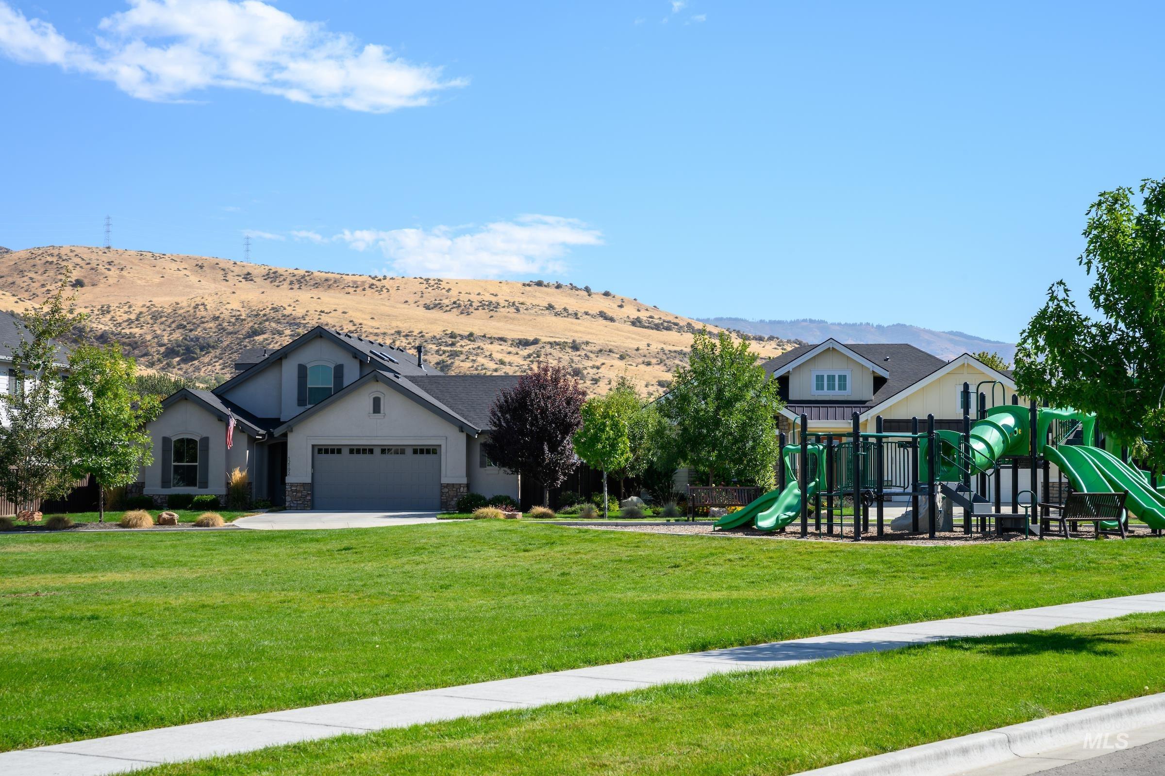View of jungle gym with a lawn and a mountain view