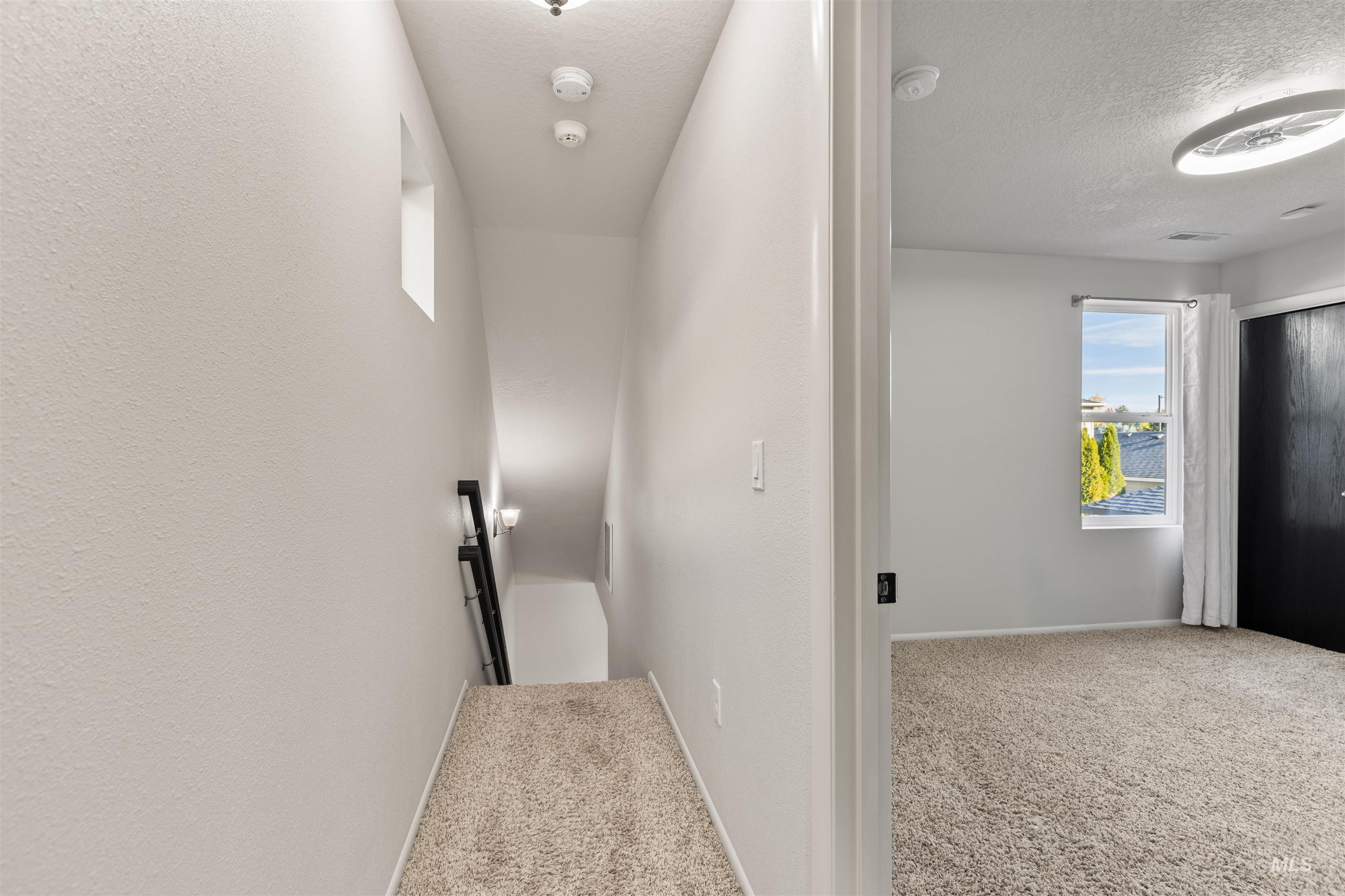 Hall featuring a textured ceiling and carpet