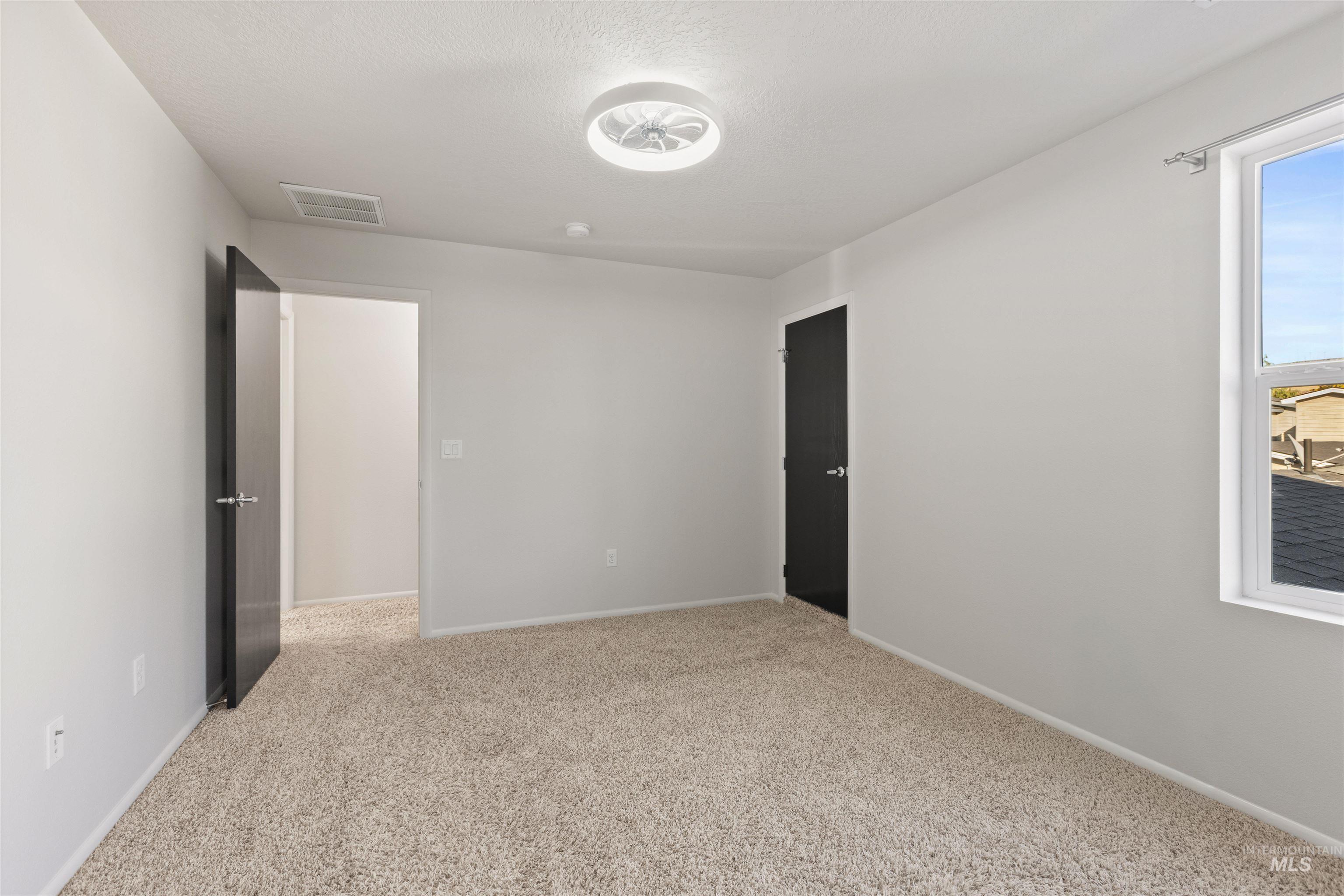 Unfurnished bedroom featuring light colored carpet and a textured ceiling