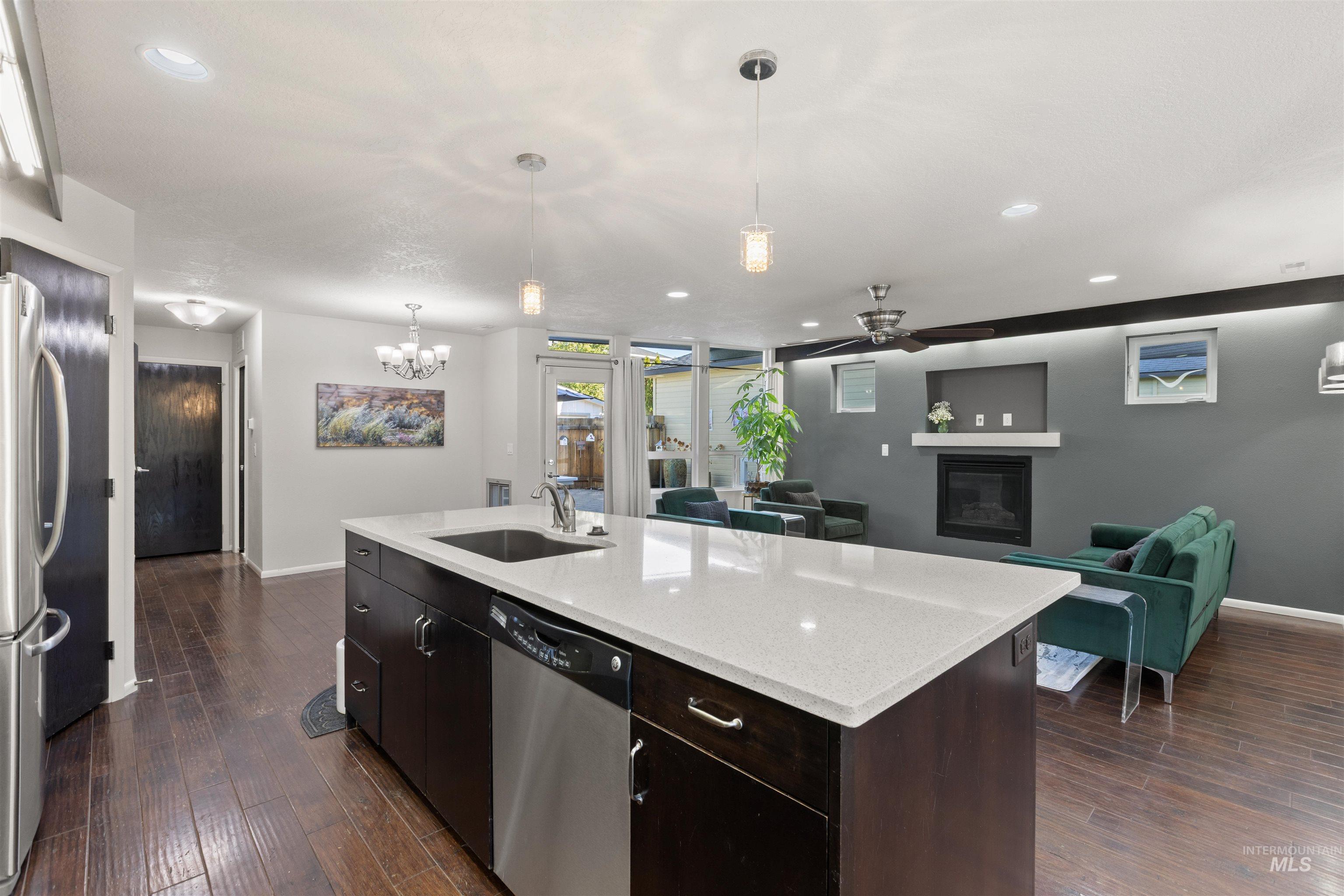 Kitchen with decorative light fixtures, stainless steel appliances, recessed lighting, open floor plan, and dark wood-style flooring