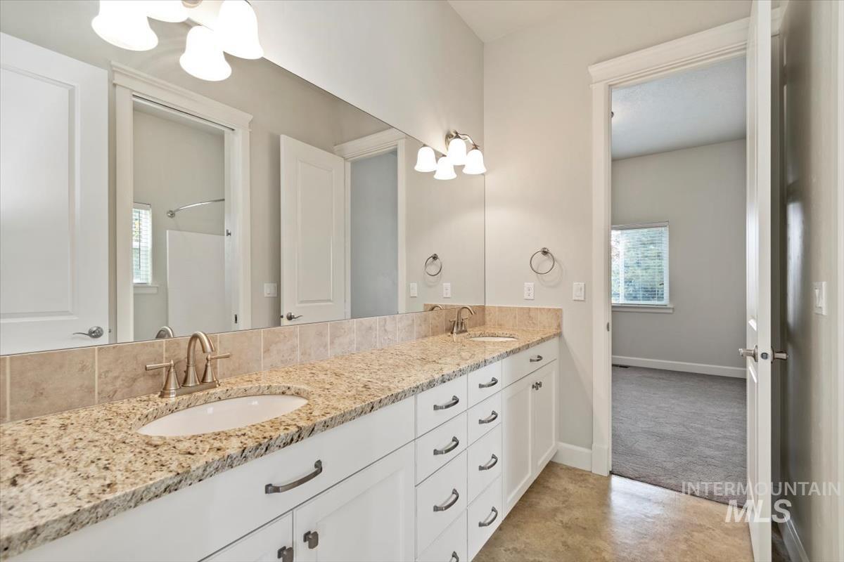 Full bath featuring double vanity and a chandelier