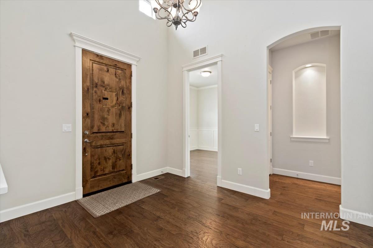 Foyer featuring dark wood finished floors and a chandelier