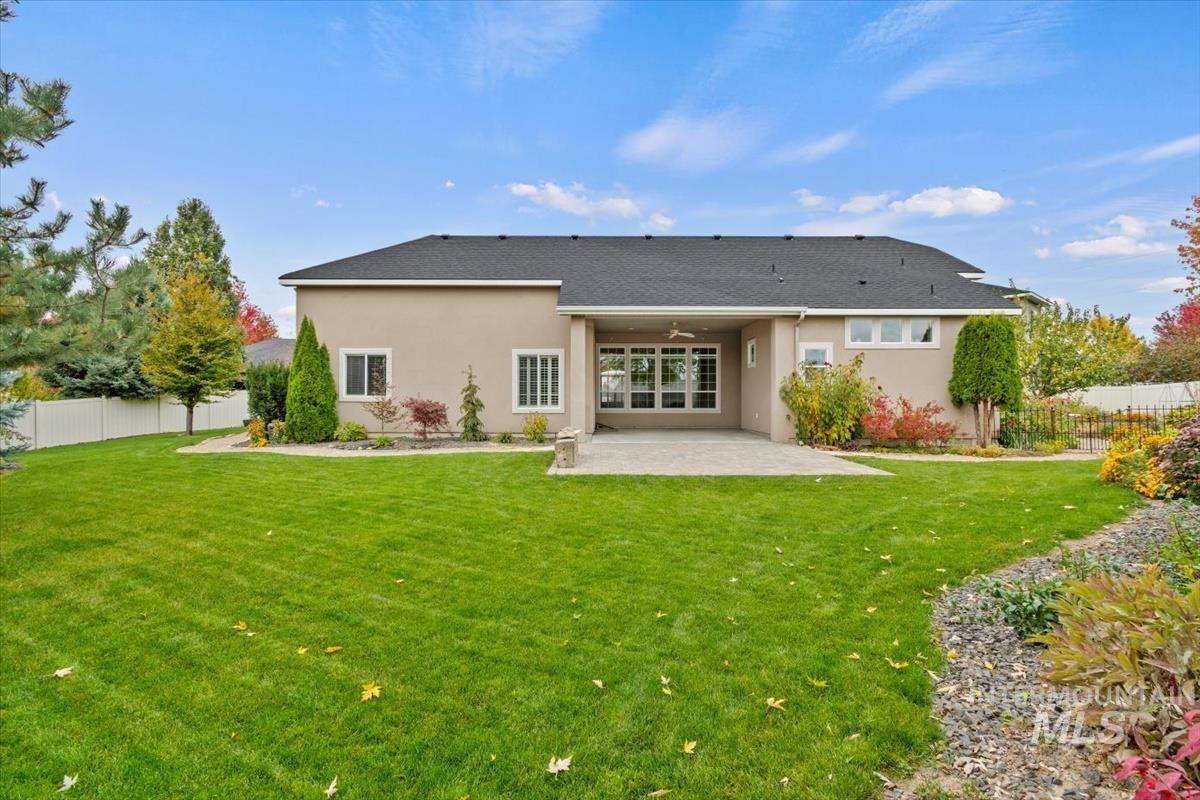 Rear view of property featuring a fenced backyard, a patio, stucco siding, and a ceiling fan
