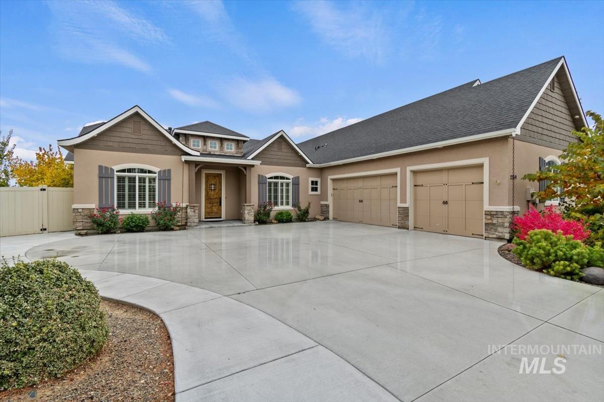 Craftsman-style home with stone siding, driveway, an attached garage, stucco siding, and a shingled roof