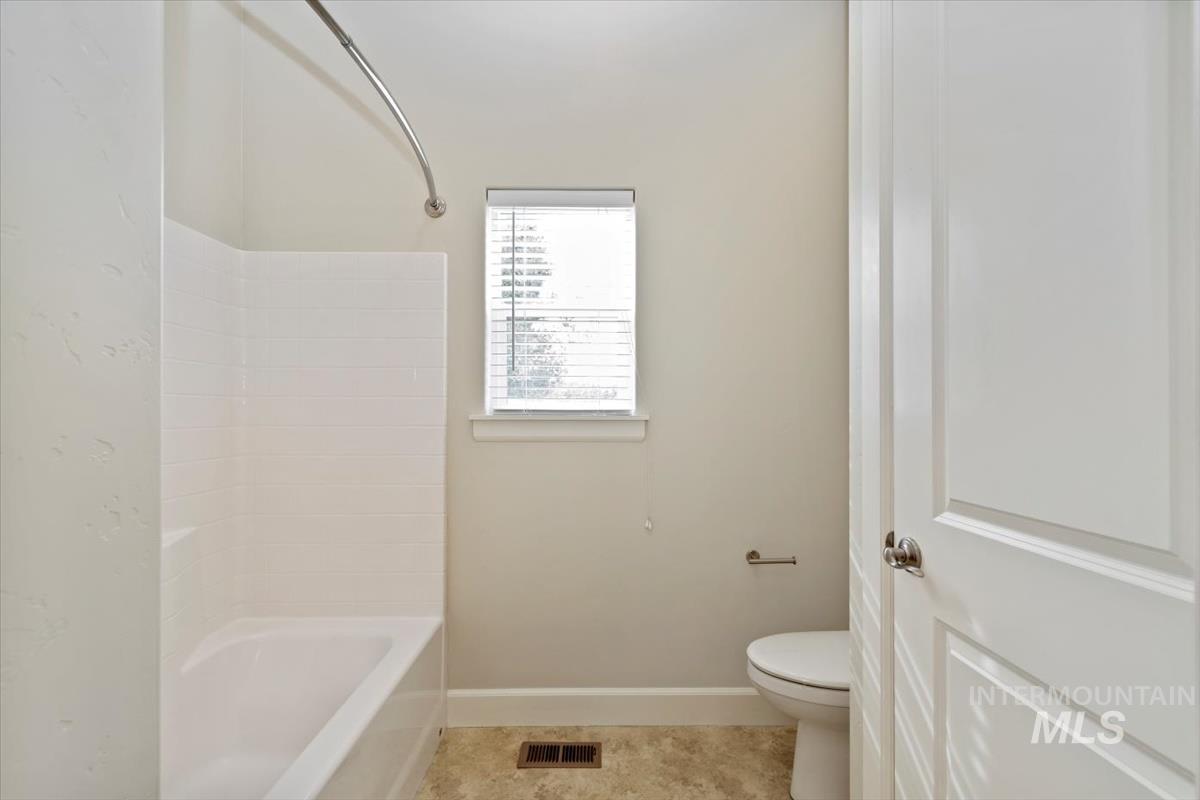 Full bathroom with shower / washtub combination and tile patterned floors