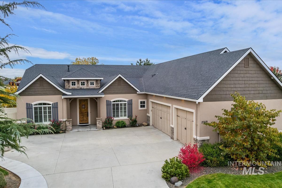 Craftsman-style home with a shingled roof, stucco siding, driveway, and a garage