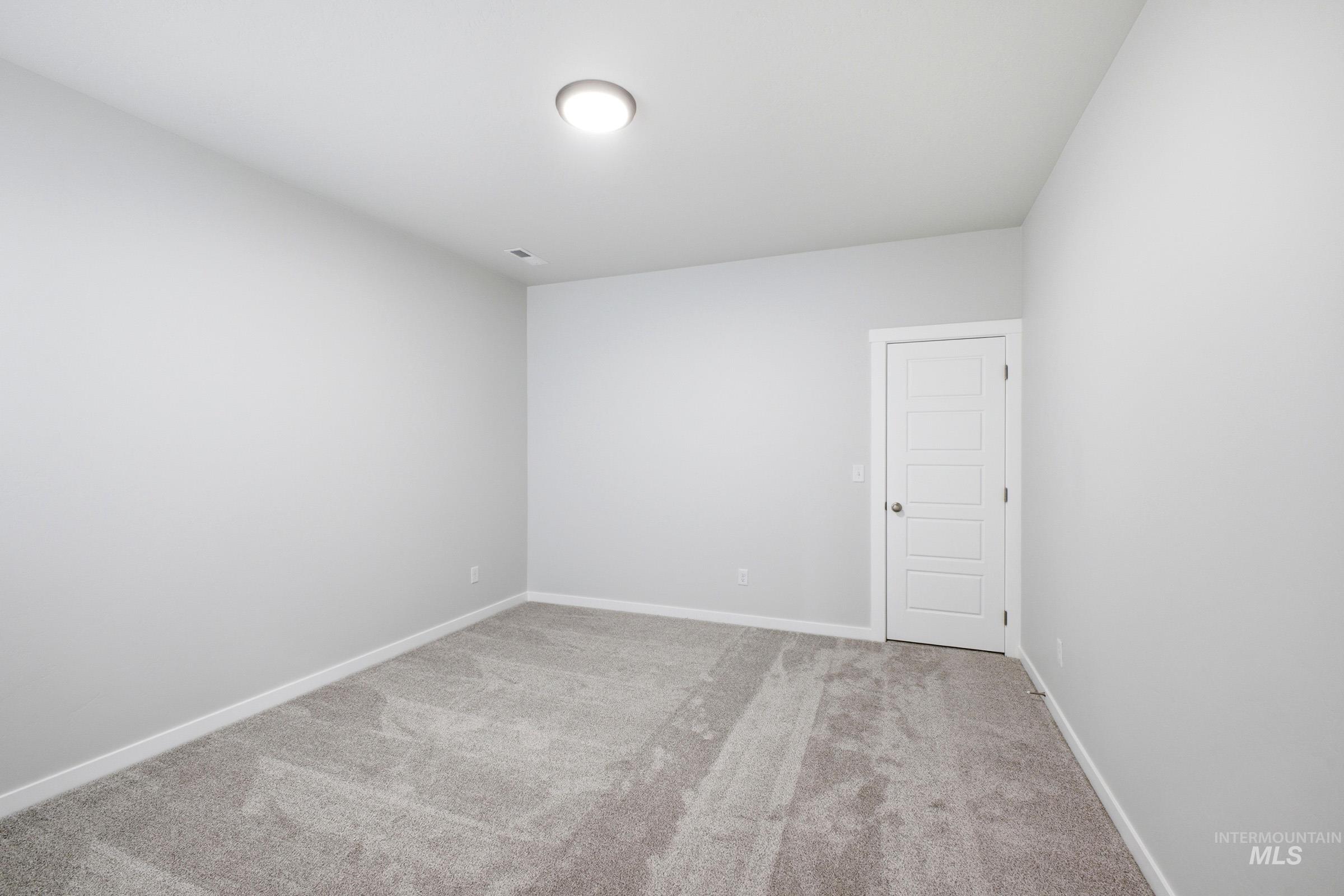 Neutral gray wall paint with white baseboards and a ceiling-mounted light fixture