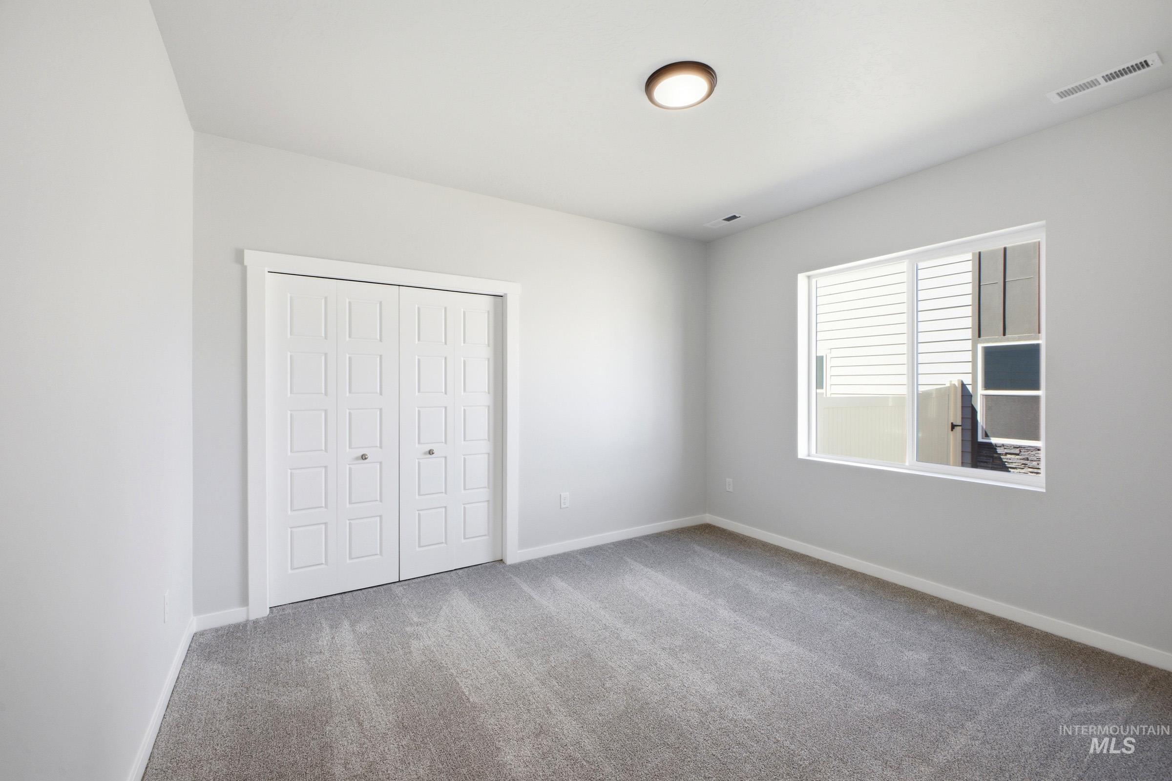 Room featuring light gray wall paint and gray carpet flooring