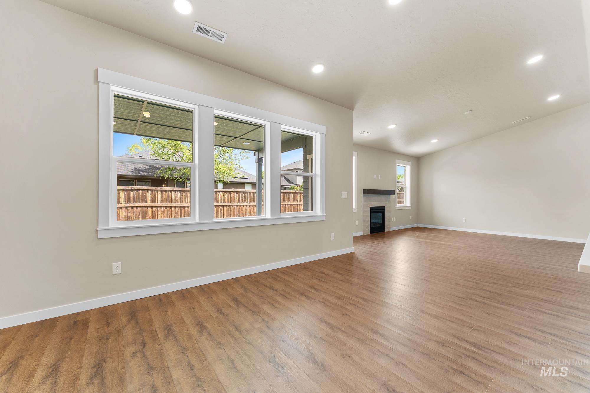 Open-concept interior featuring wood-finish flooring, recessed lighting, and a neutral wall palette