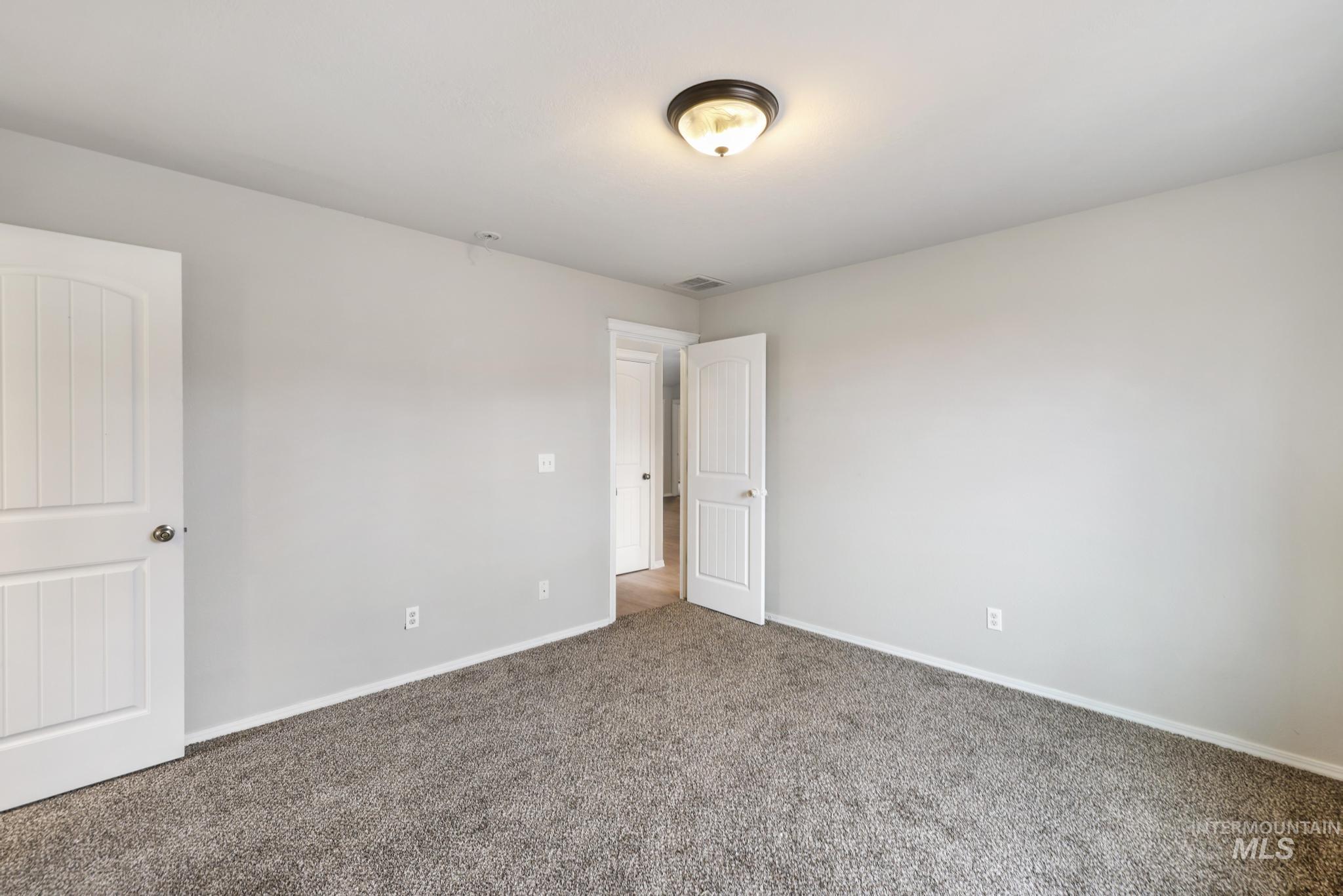 Carpeted empty room with baseboards