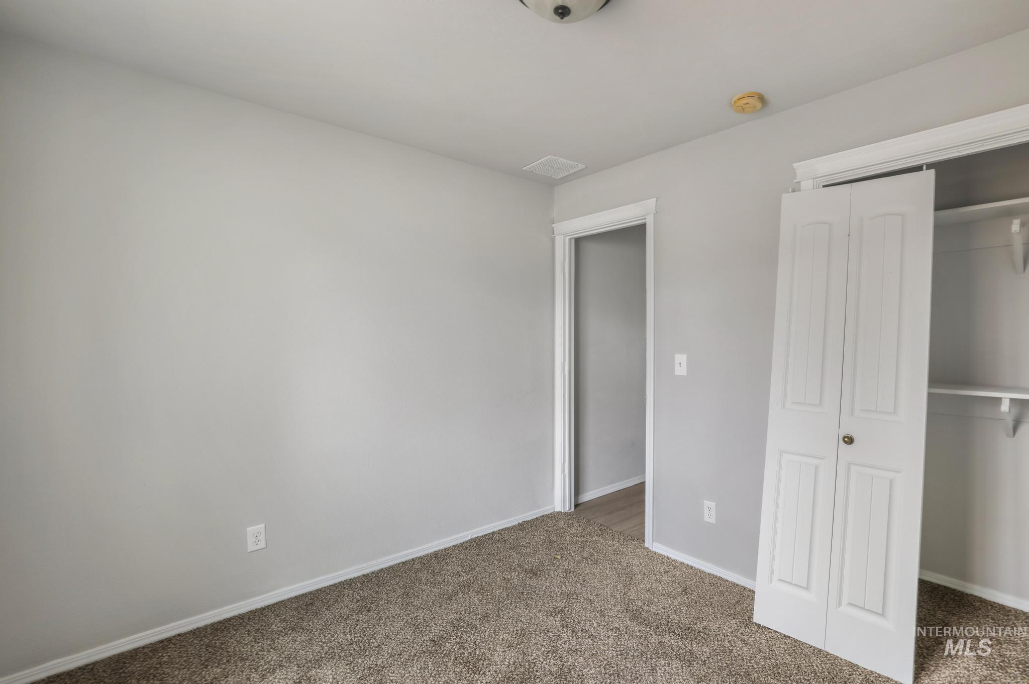 Unfurnished bedroom with carpet and a closet