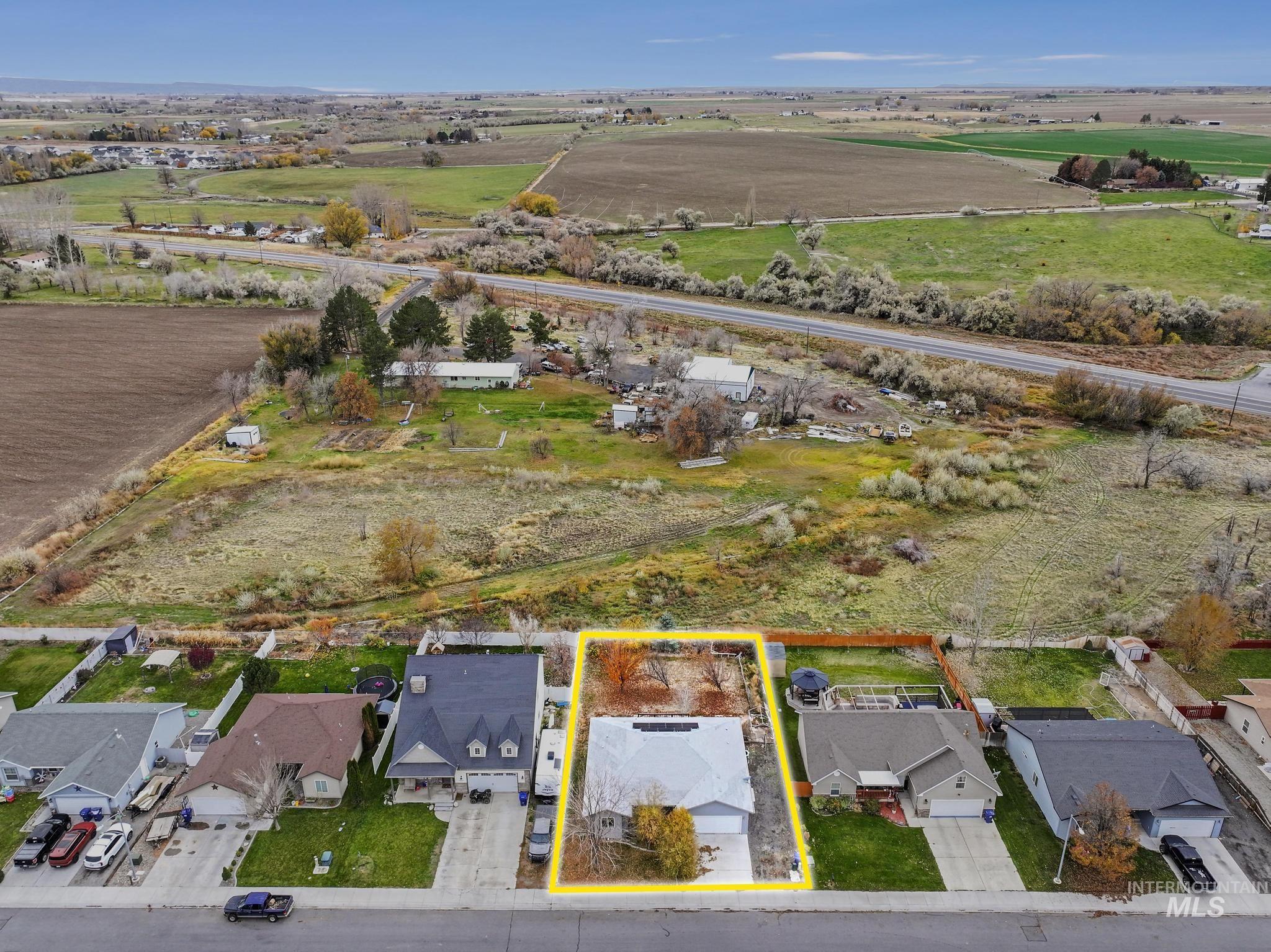 View of rural area with property parcel outlined and nearby suburban area