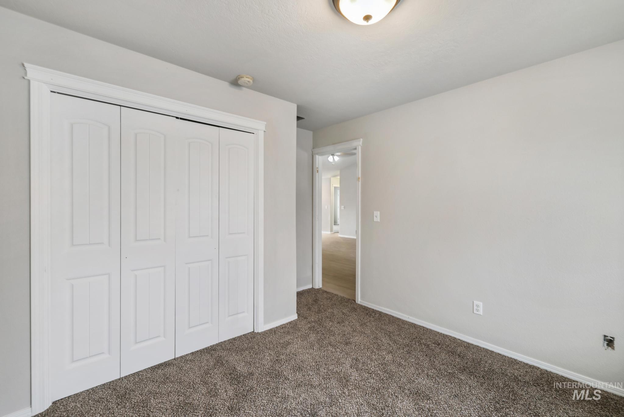 Unfurnished bedroom featuring carpet and a closet