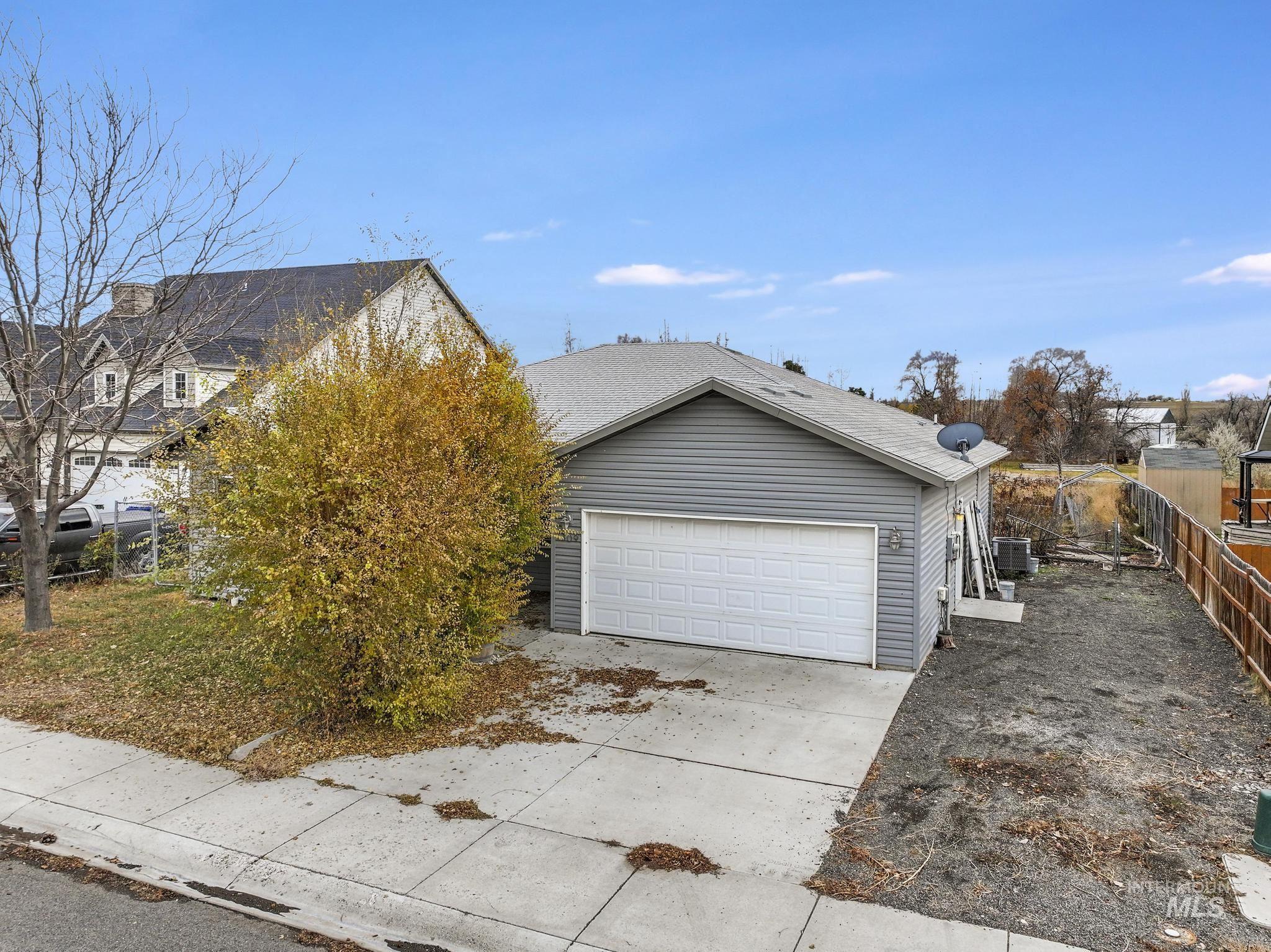 View of side of home featuring concrete driveway and an attached garage