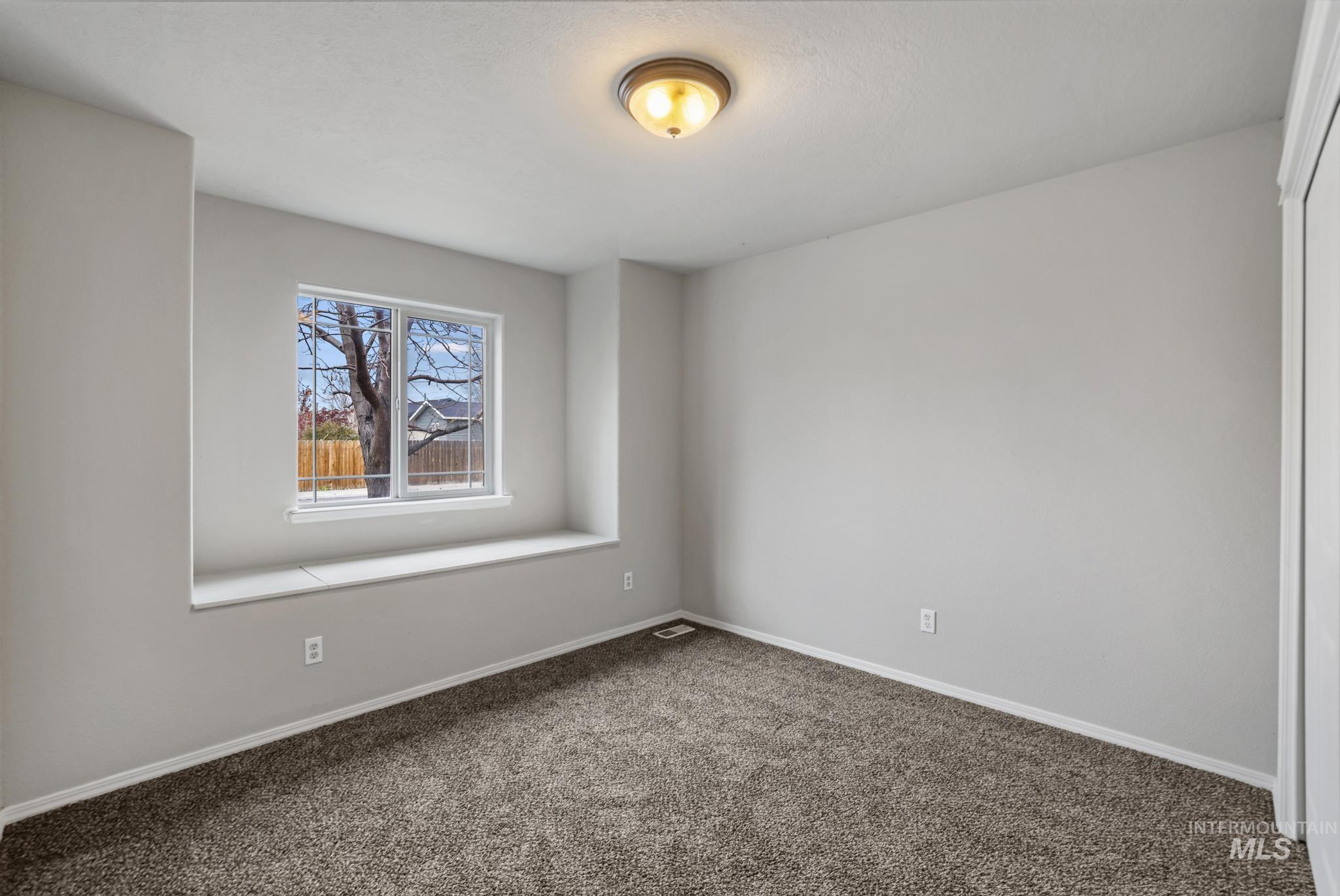 Empty room featuring baseboards and carpet flooring