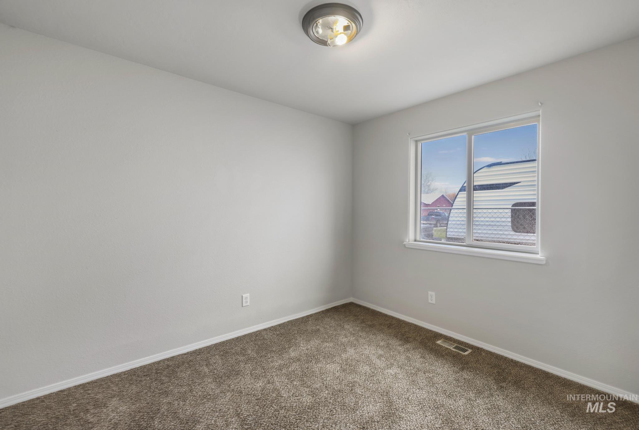 Spare room with carpet and baseboards