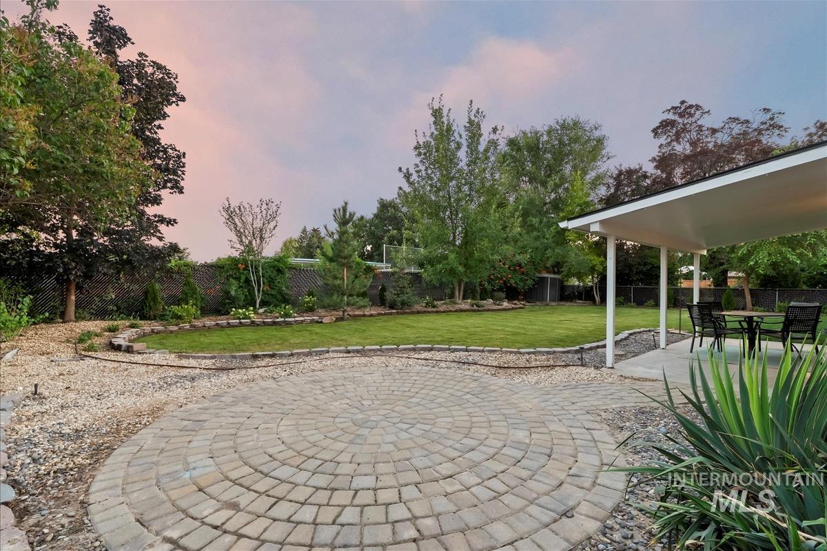 Patio terrace at dusk with a patio, a fenced backyard, and outdoor dining space
