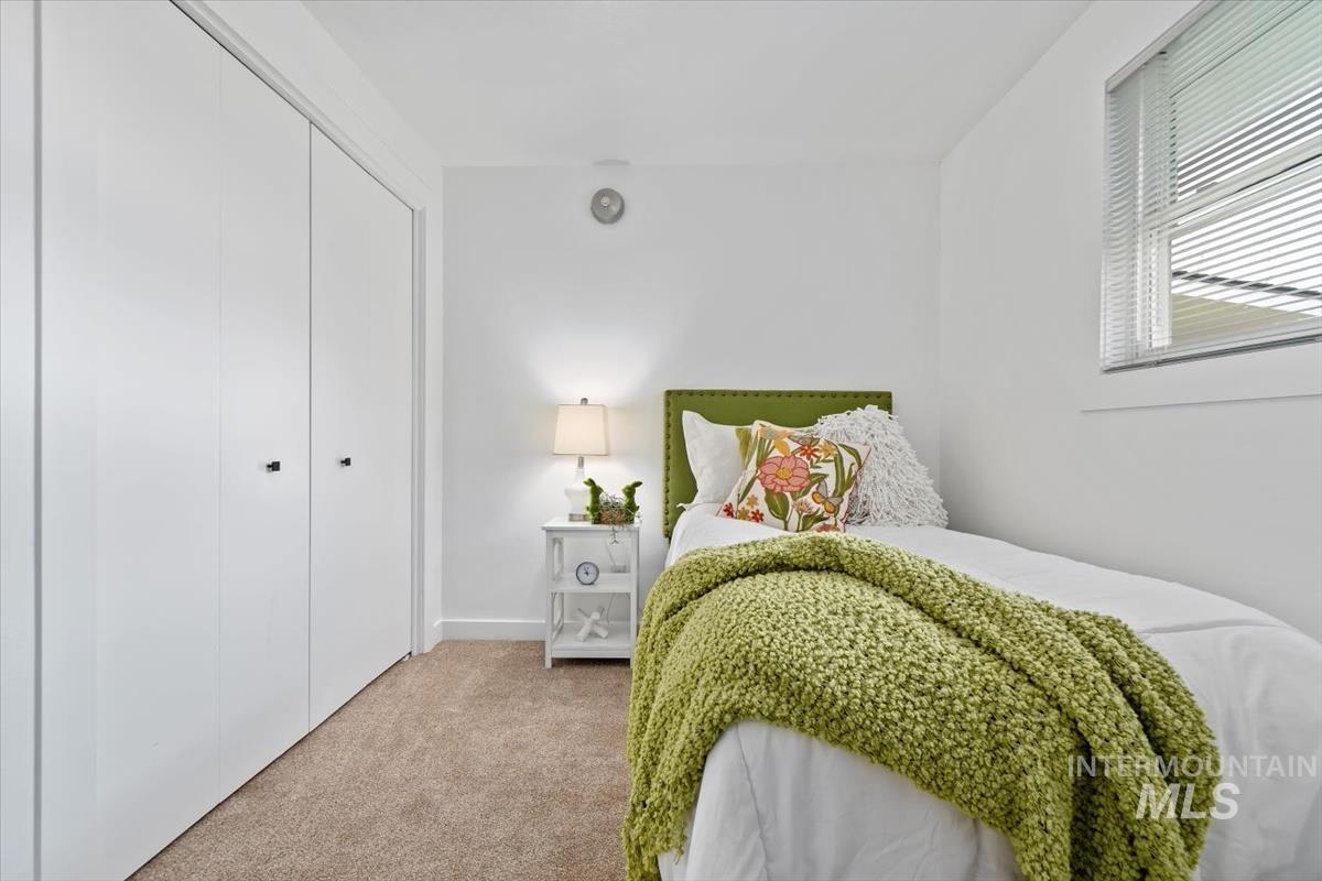 Carpeted bedroom with a closet and baseboards