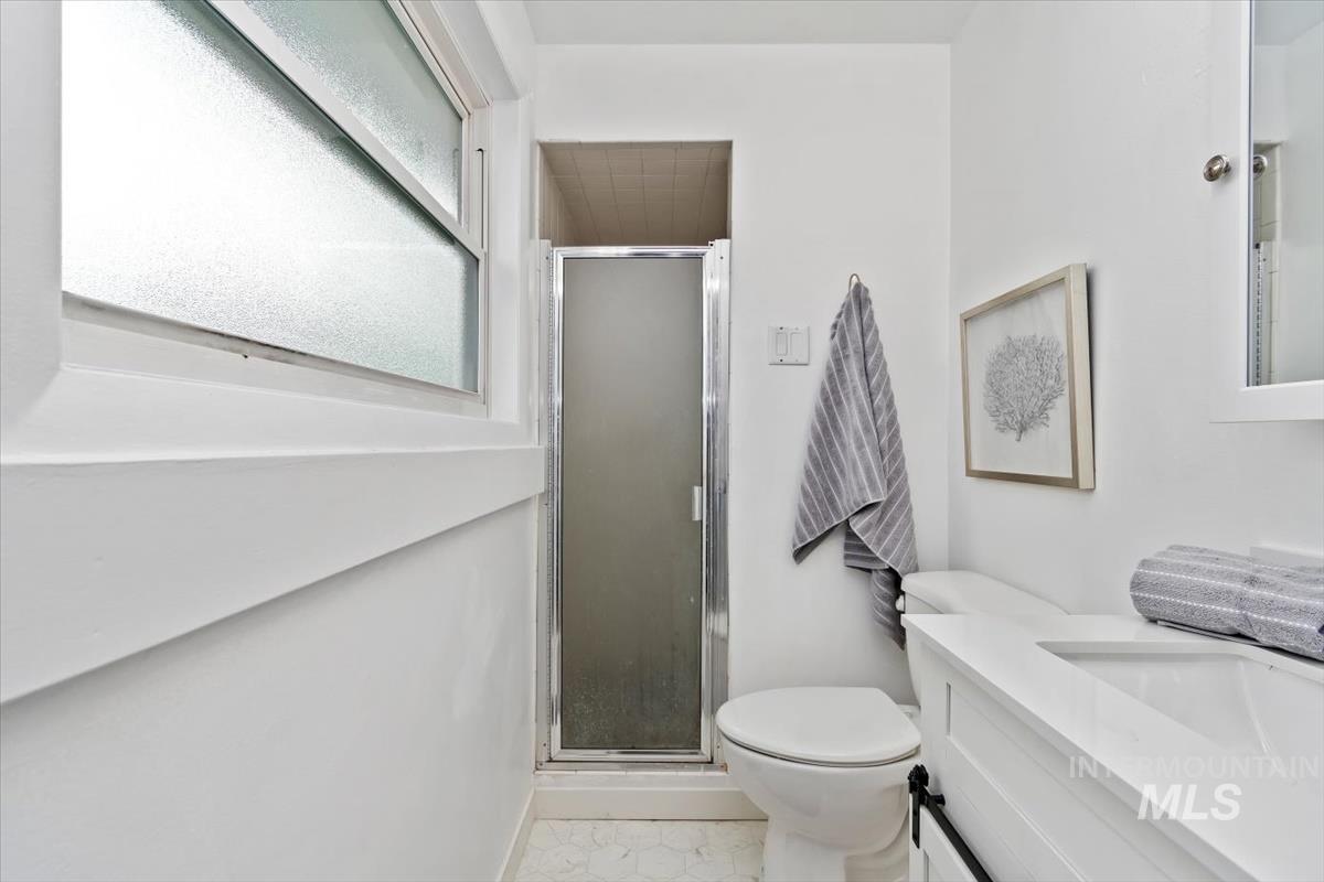 Bathroom with vanity, a shower stall, and light tile patterned flooring