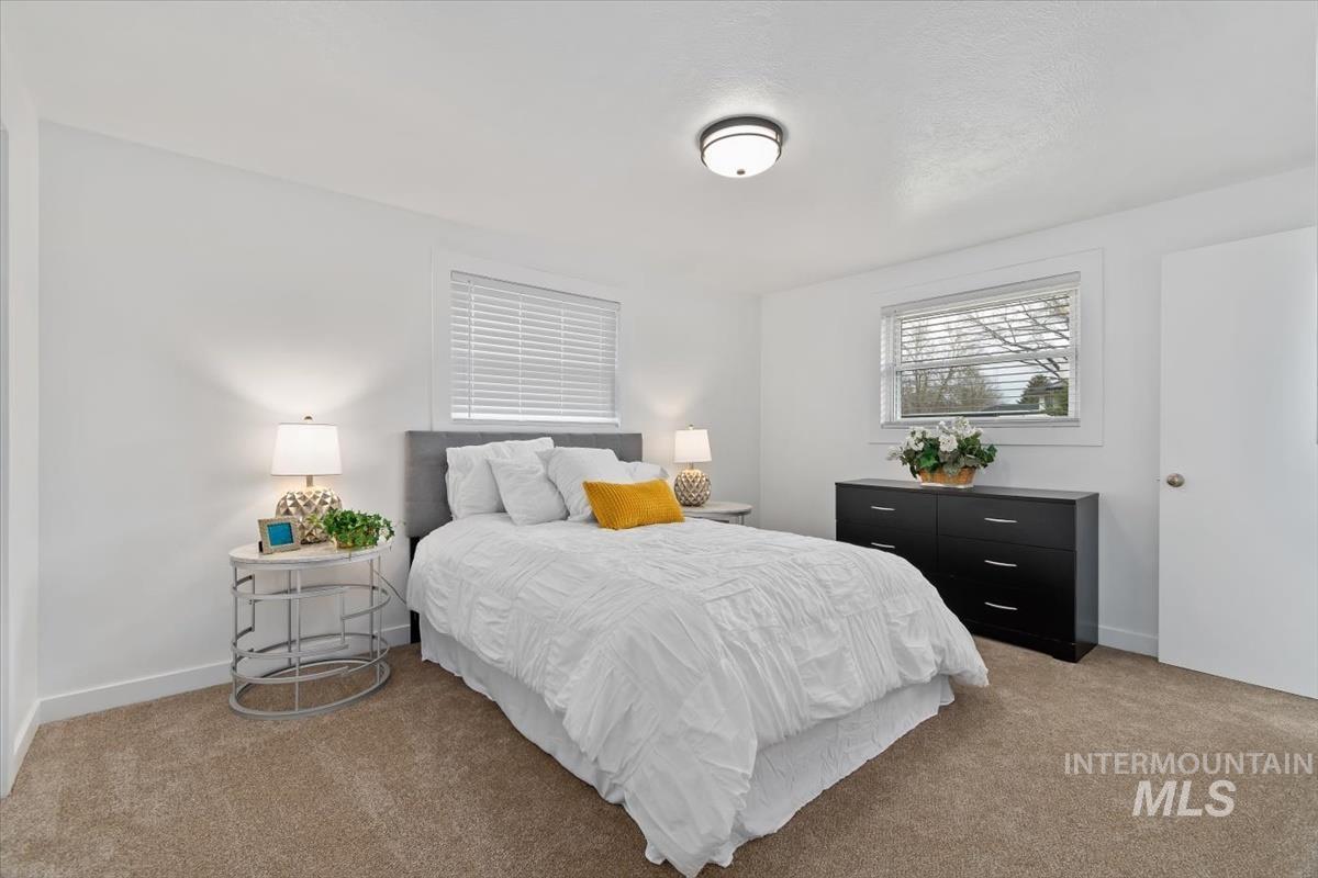 Bedroom with light colored carpet and baseboards