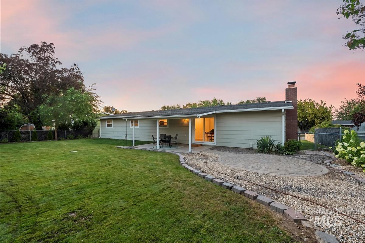 Back of property with a fenced backyard, a patio, and a chimney