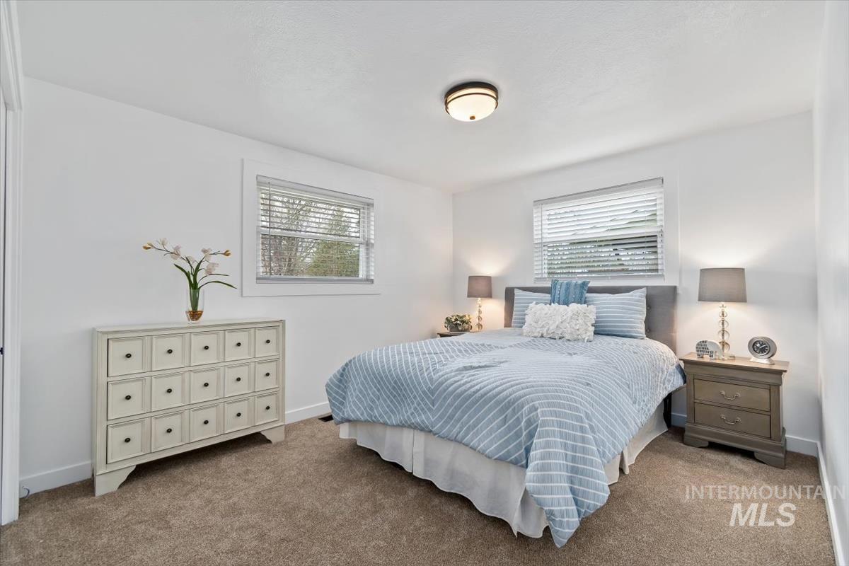 Carpeted bedroom featuring multiple windows
