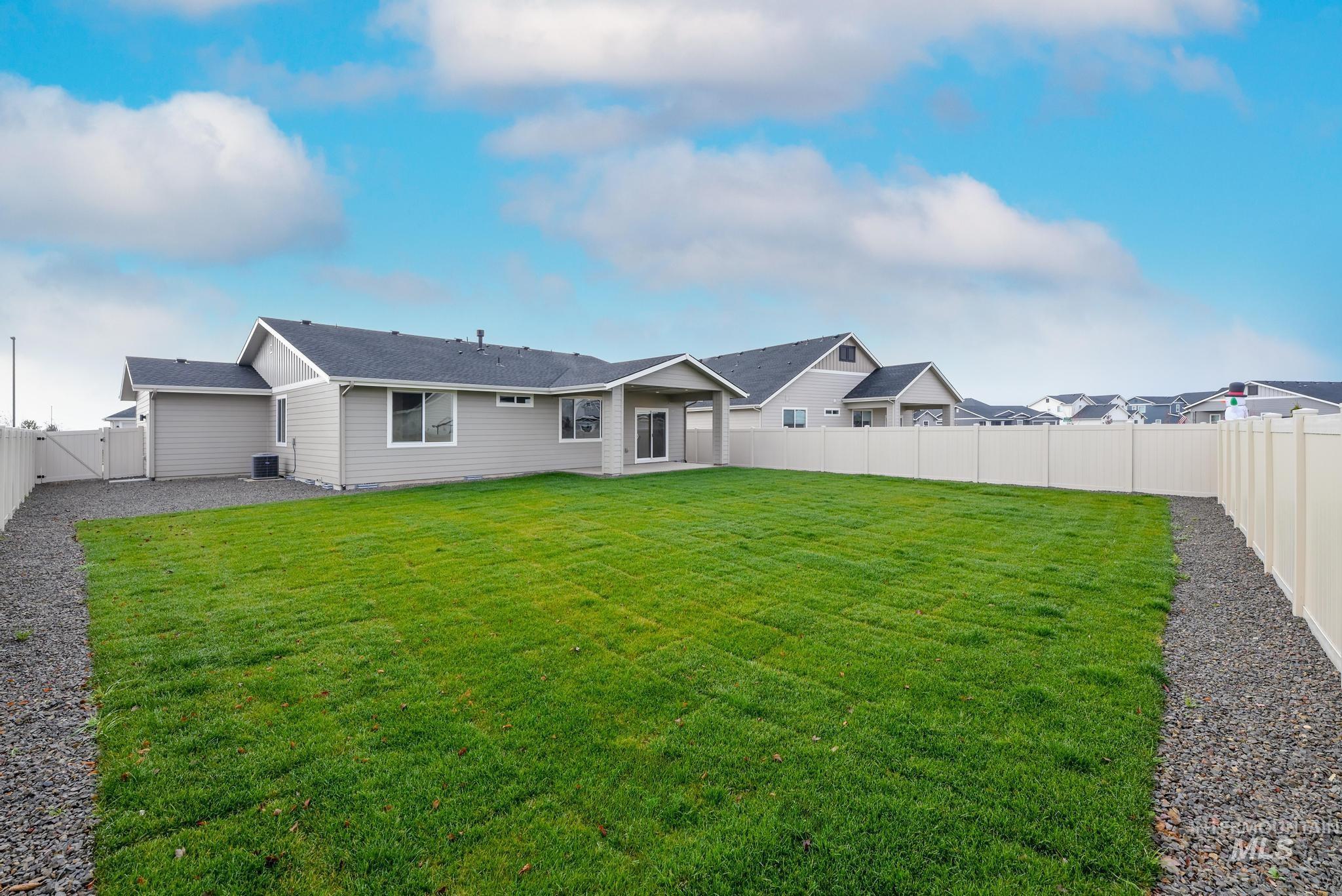 Rear view of property with a fenced backyard, a patio area, a gate, and roof with shingles
