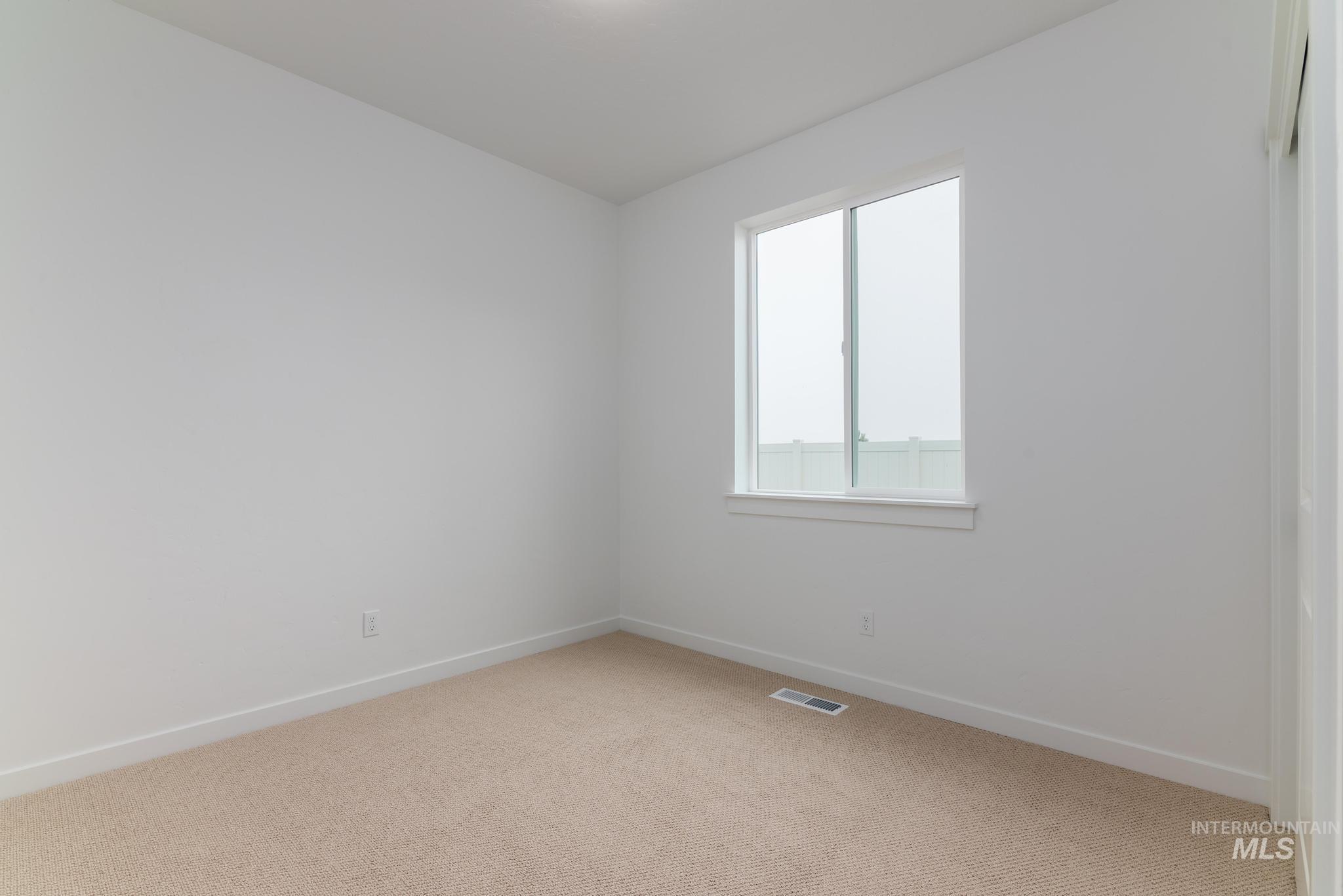 Spare room featuring baseboards and light colored carpet