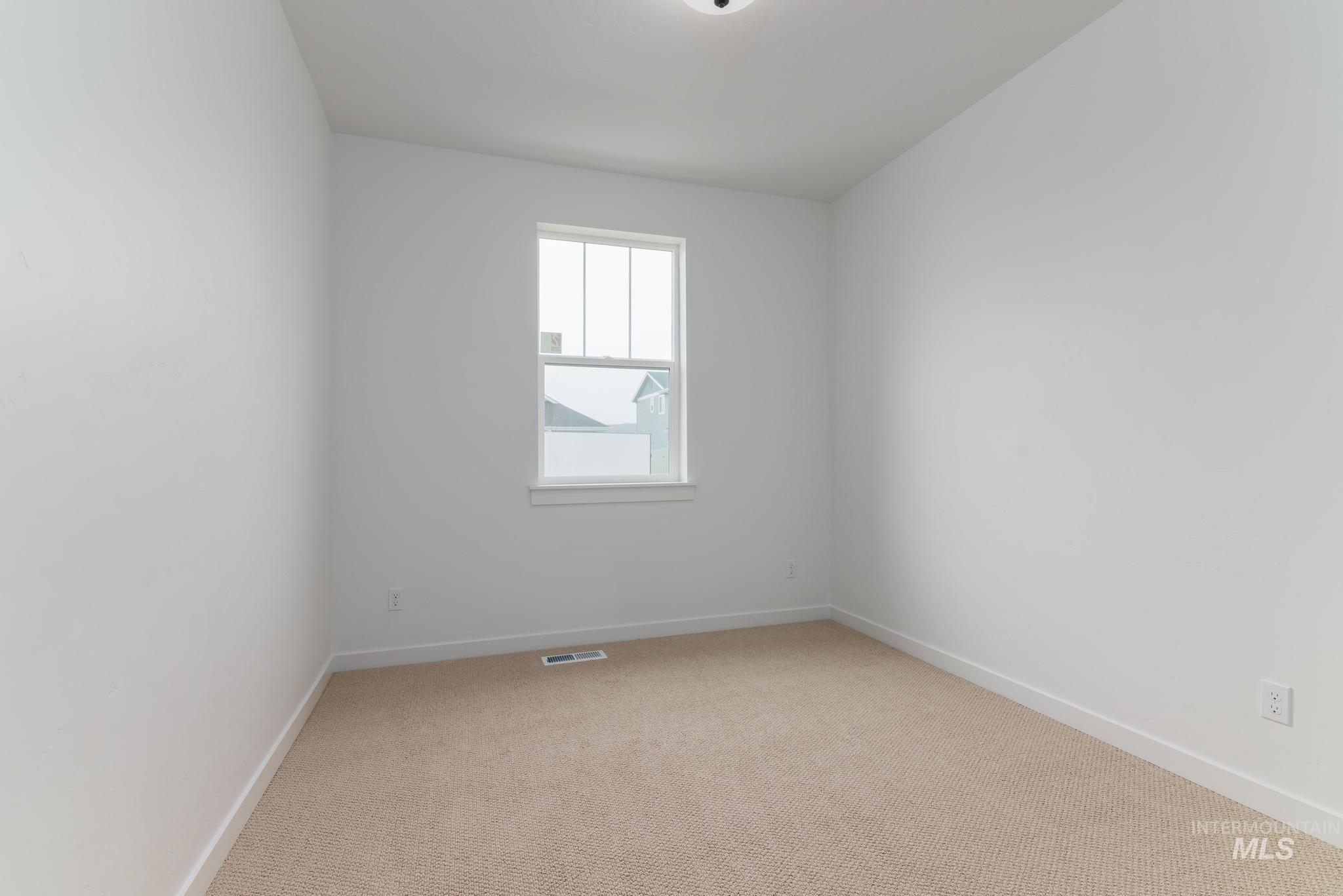 Empty room featuring light carpet and baseboards