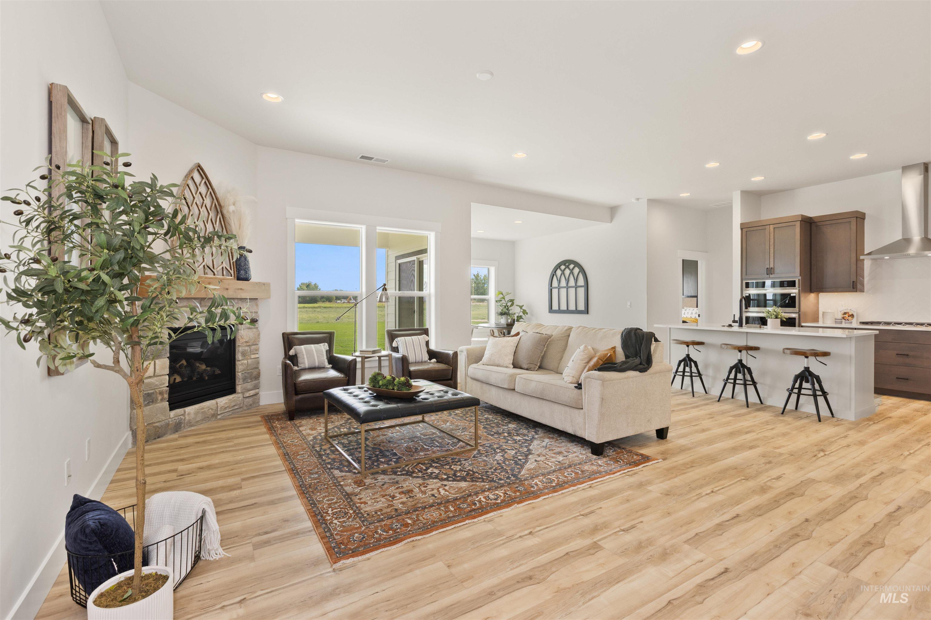 Living room featuring a fireplace, recessed lighting, and light wood finished floors