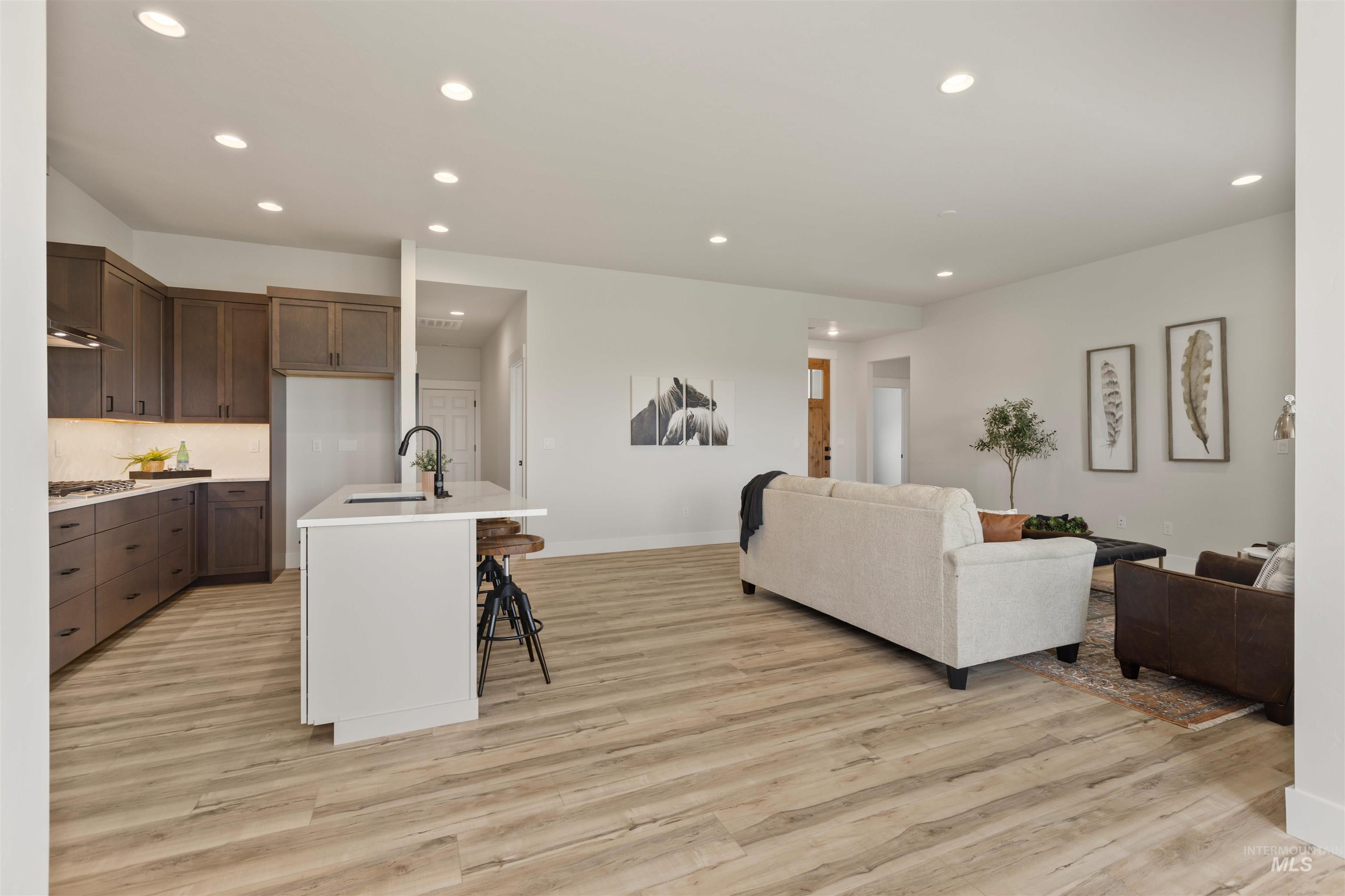 Living area with recessed lighting and light wood-style flooring