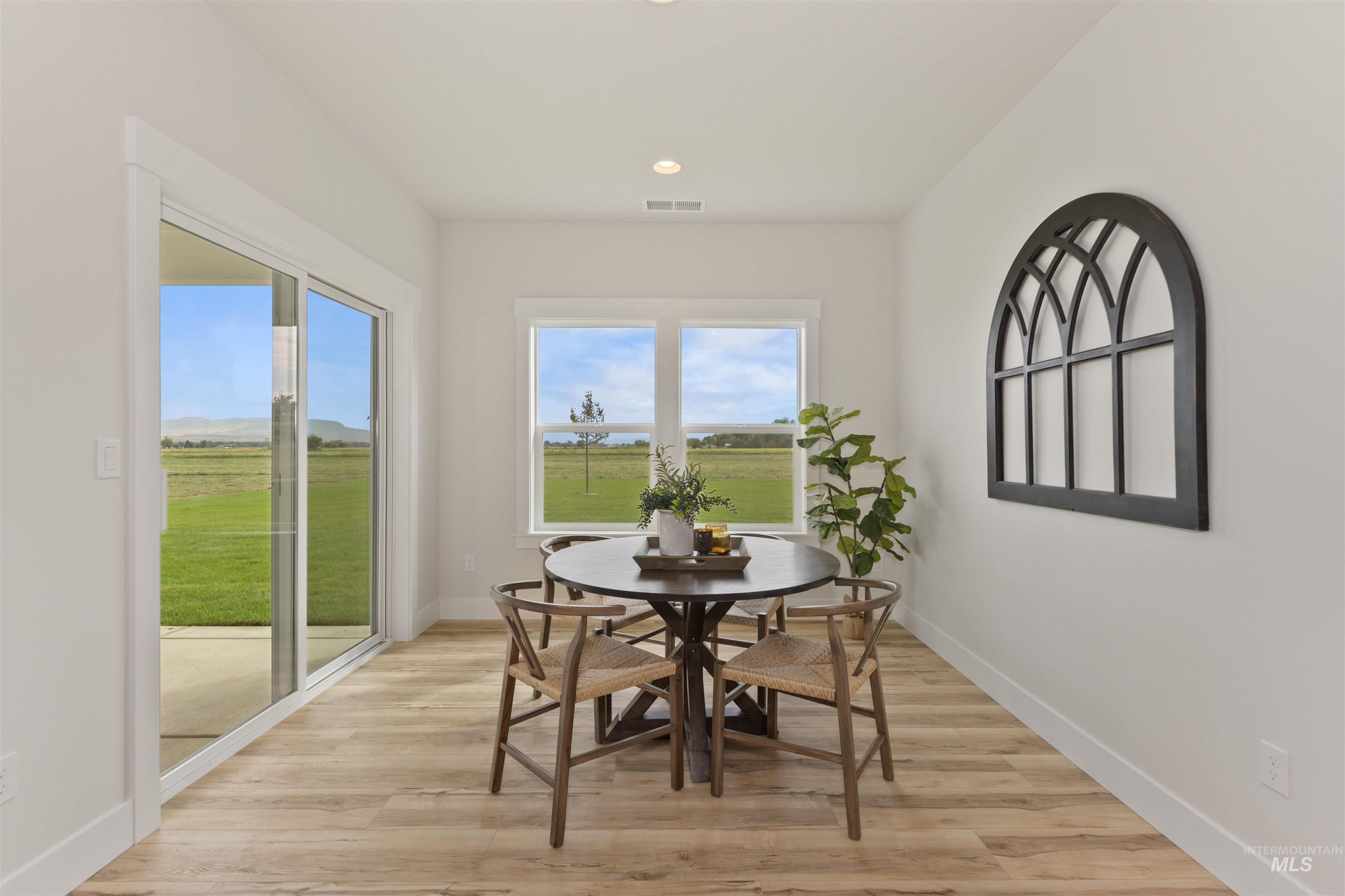 Dining space with light wood finished floors and recessed lighting