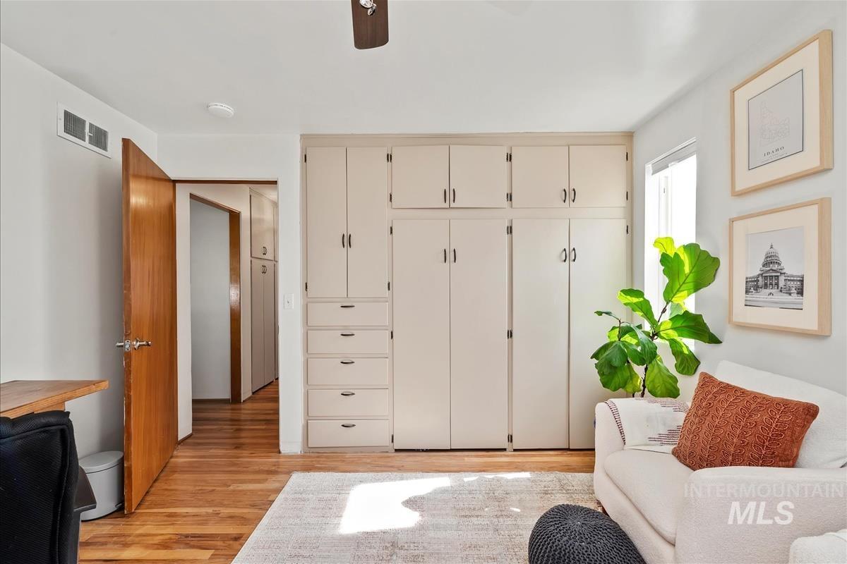 Sitting room with light wood-style floors and a ceiling fan