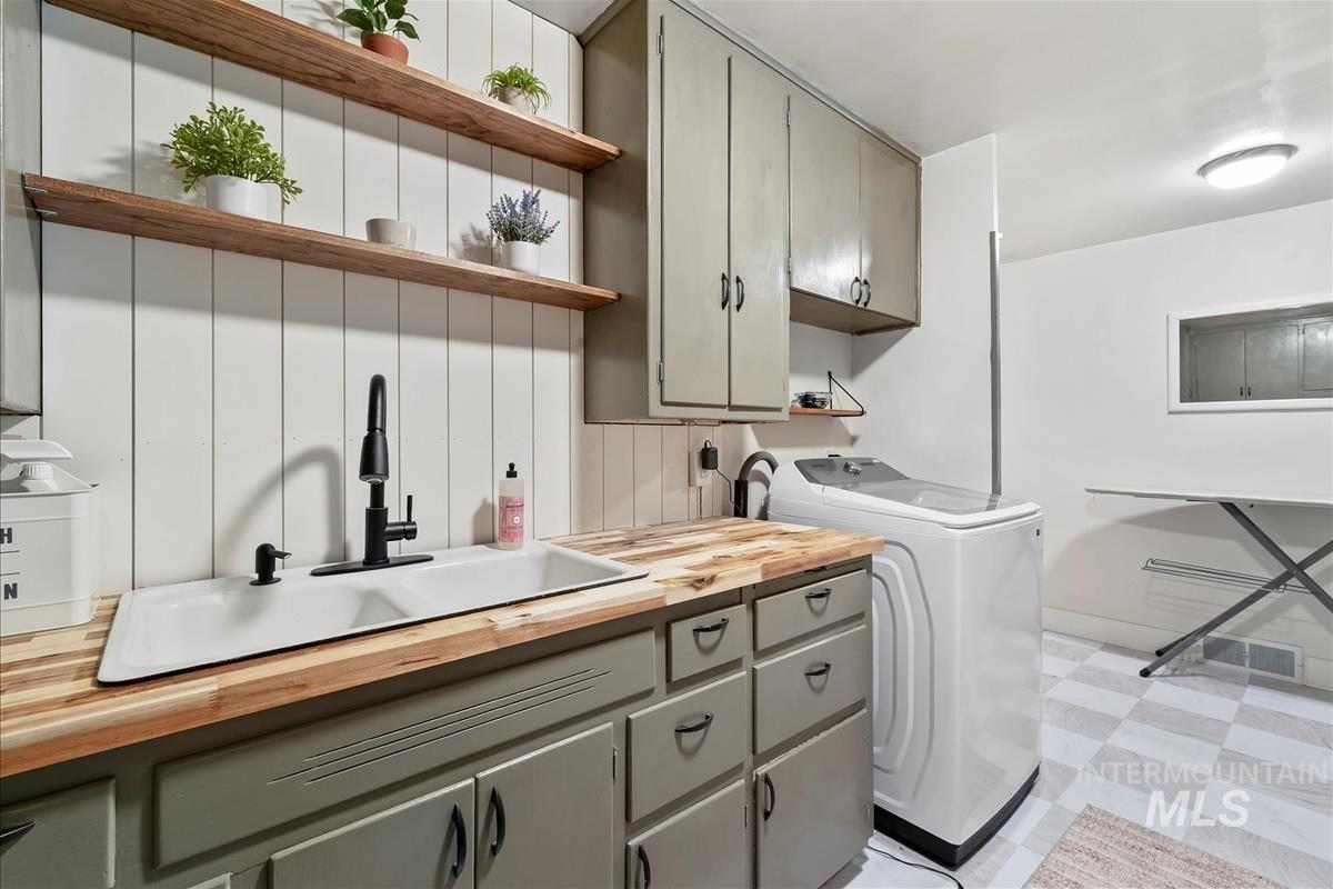 Washroom featuring light flooring, cabinet space, and electric dryer hookup