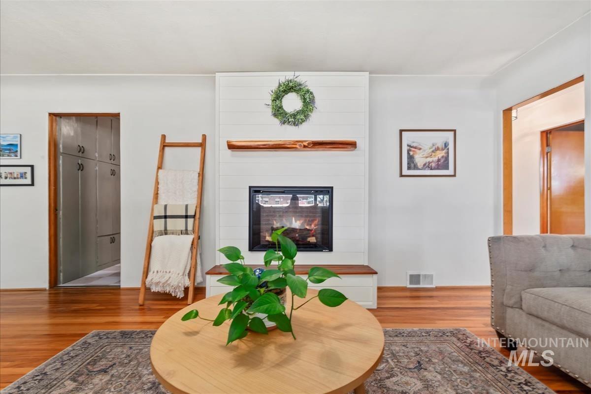 Living room featuring wood finished floors and a large fireplace