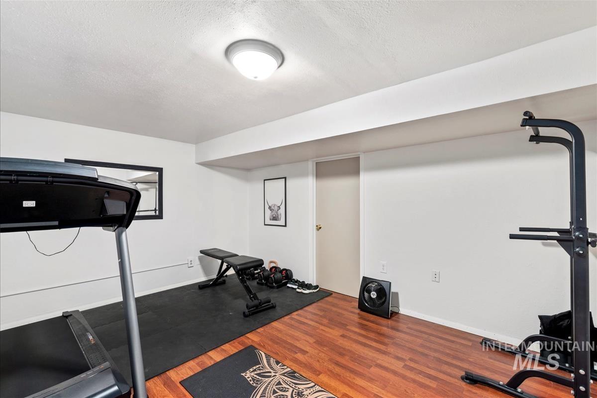 Exercise area featuring wood finished floors and a textured ceiling