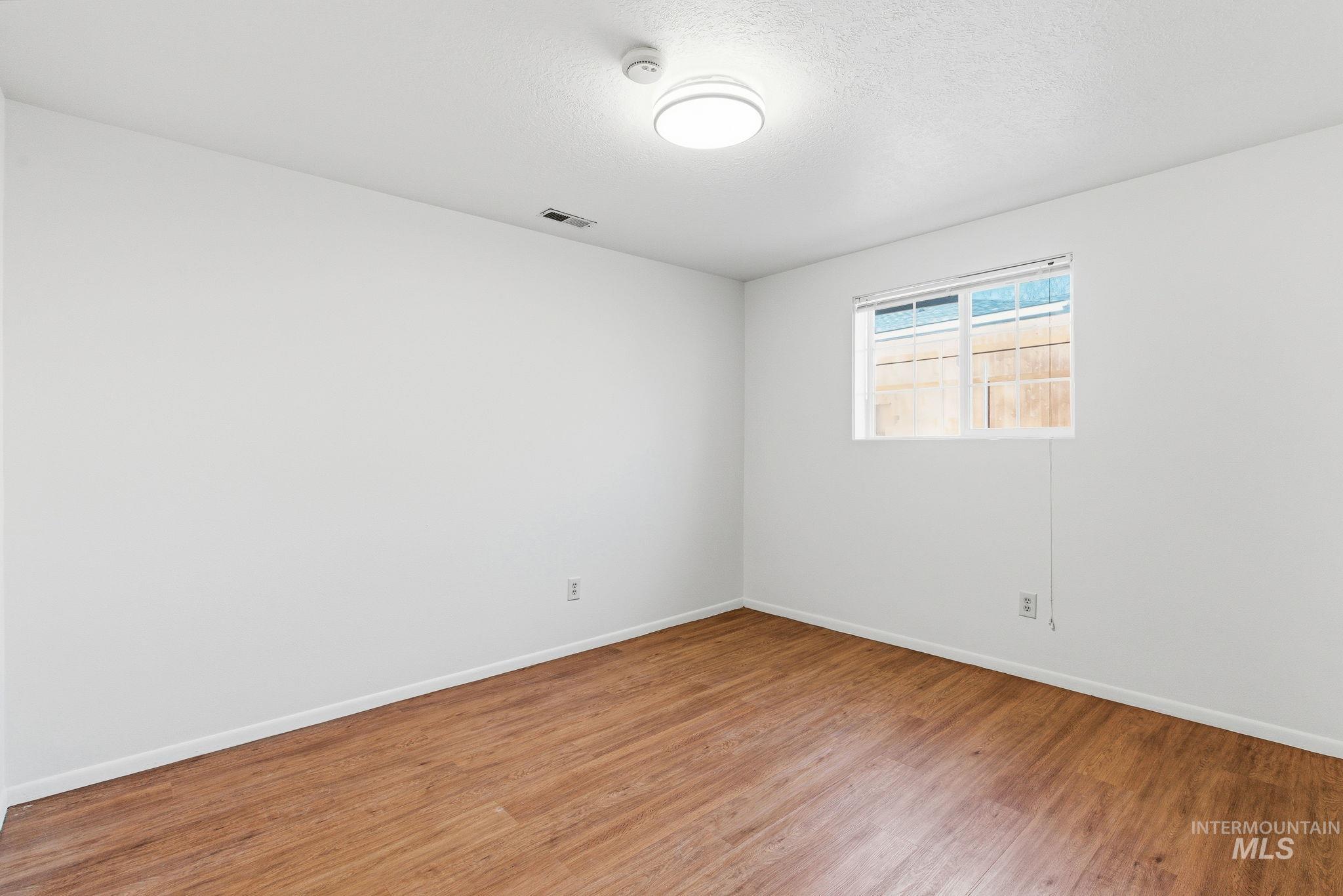 Empty room featuring baseboards and wood finished floors