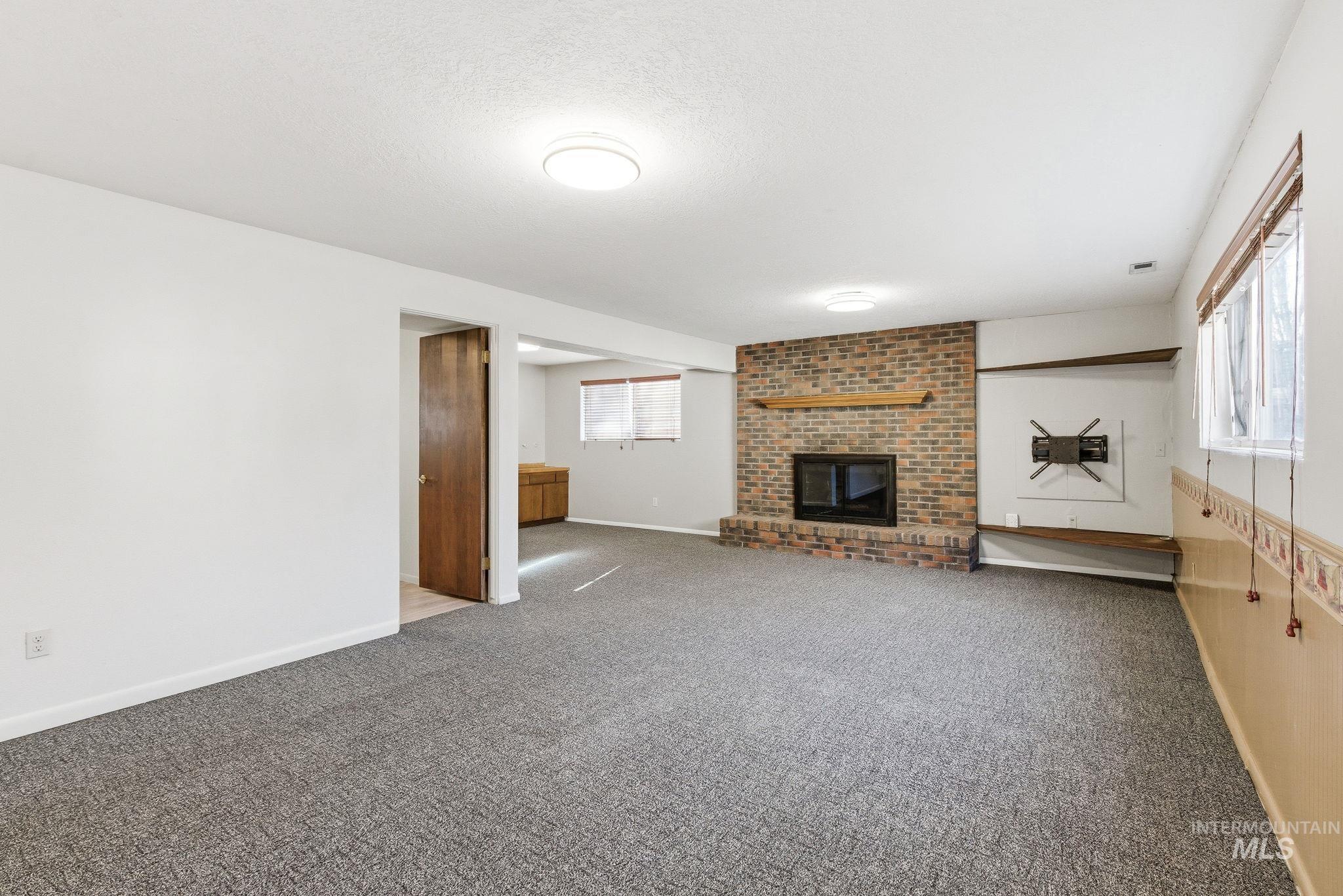 Unfurnished living room featuring a fireplace and carpet